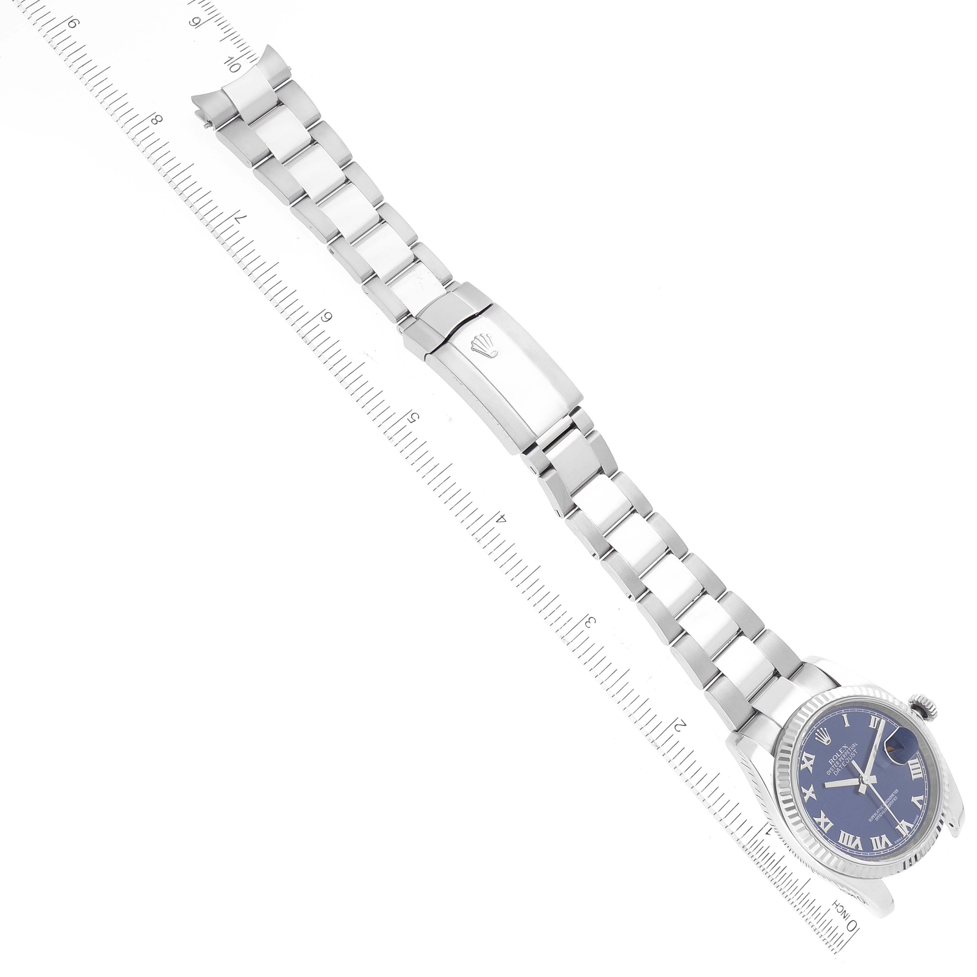 The image shows a top-down view of a Rolex Datejust 116234 Men's Stainless Steel Blue Dial 116234 Men's Stainless Steel Blue Dial watch, including its full bracelet and clasp, alongside a ruler for measurement.