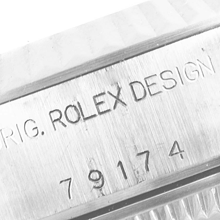 The image shows a close-up of the serial number and "ROLEX DESIGN" engraving on the case of a Rolex Datejust 79174 Women
s Stainless Steel Mother of Pearl Dial 79174 Women
s Stainless Steel Mother of Pearl Dial watch.