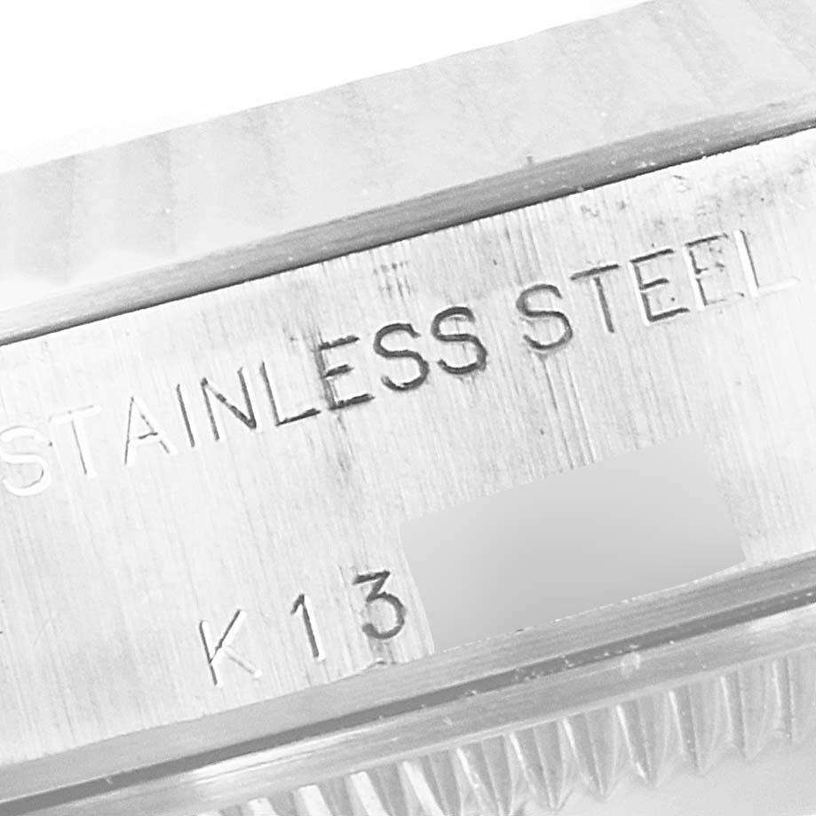 The image shows a close-up of the side of the bezel and case back with engraved text on a Rolex Datejust 79174 Women
s Stainless Steel Mother of Pearl Dial 79174 Women
s Stainless Steel Mother of Pearl Dial model.