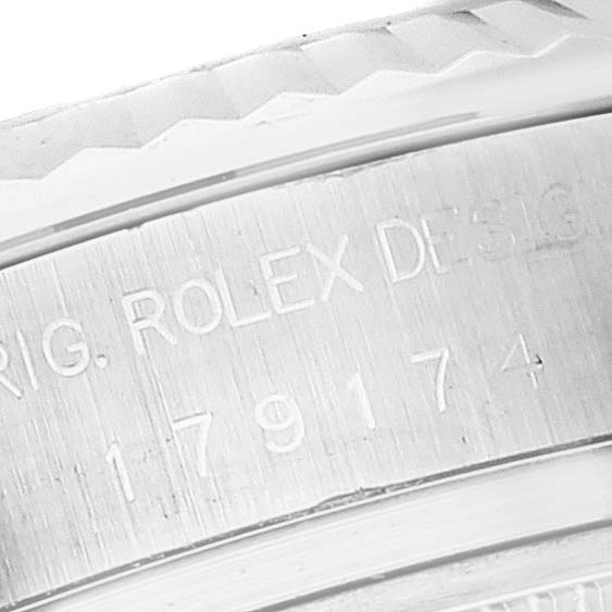 This close-up image shows the engraved serial number and "Rolex Design" text on the Rolex Datejust 179174 Women
s Stainless Steel Mother of Pearl Dial 179174 Women
s Stainless Steel Mother of Pearl Dial watch case.
