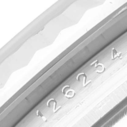 This close-up image shows the side of a Rolex Datejust 126234 Men's Stainless Steel Silver Dial 126234 Men's Stainless Steel Silver Dial watch bezel with visible serial or reference numbers.