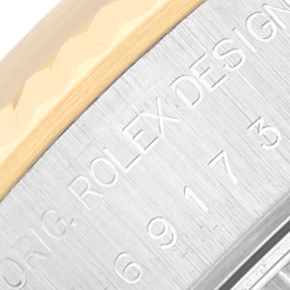 The image shows a close-up of the edge of the case and bezel of a Rolex Datejust 69173 Women's Steel and Gold (two tone) Champagne Dial 69173 Women's Steel and Gold (two tone) Champagne Dial watch, highlighting the engraved Rolex Design text.