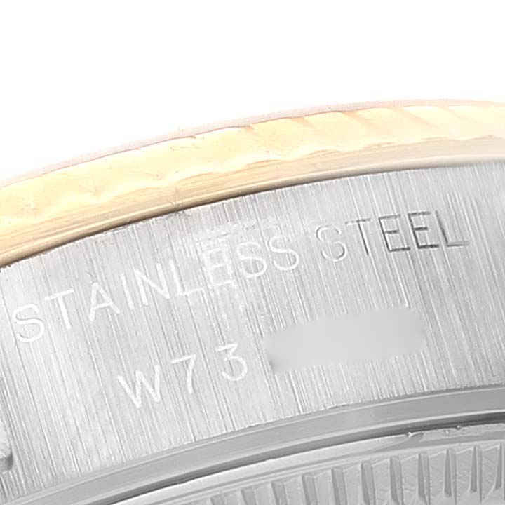 Close-up of the edge of a Rolex Datejust 69173 Women
s Steel and Gold (two tone) White Dial 69173 Women
s Steel and Gold (two tone) White Dial watch, showing part of the stainless steel case and engraved text.