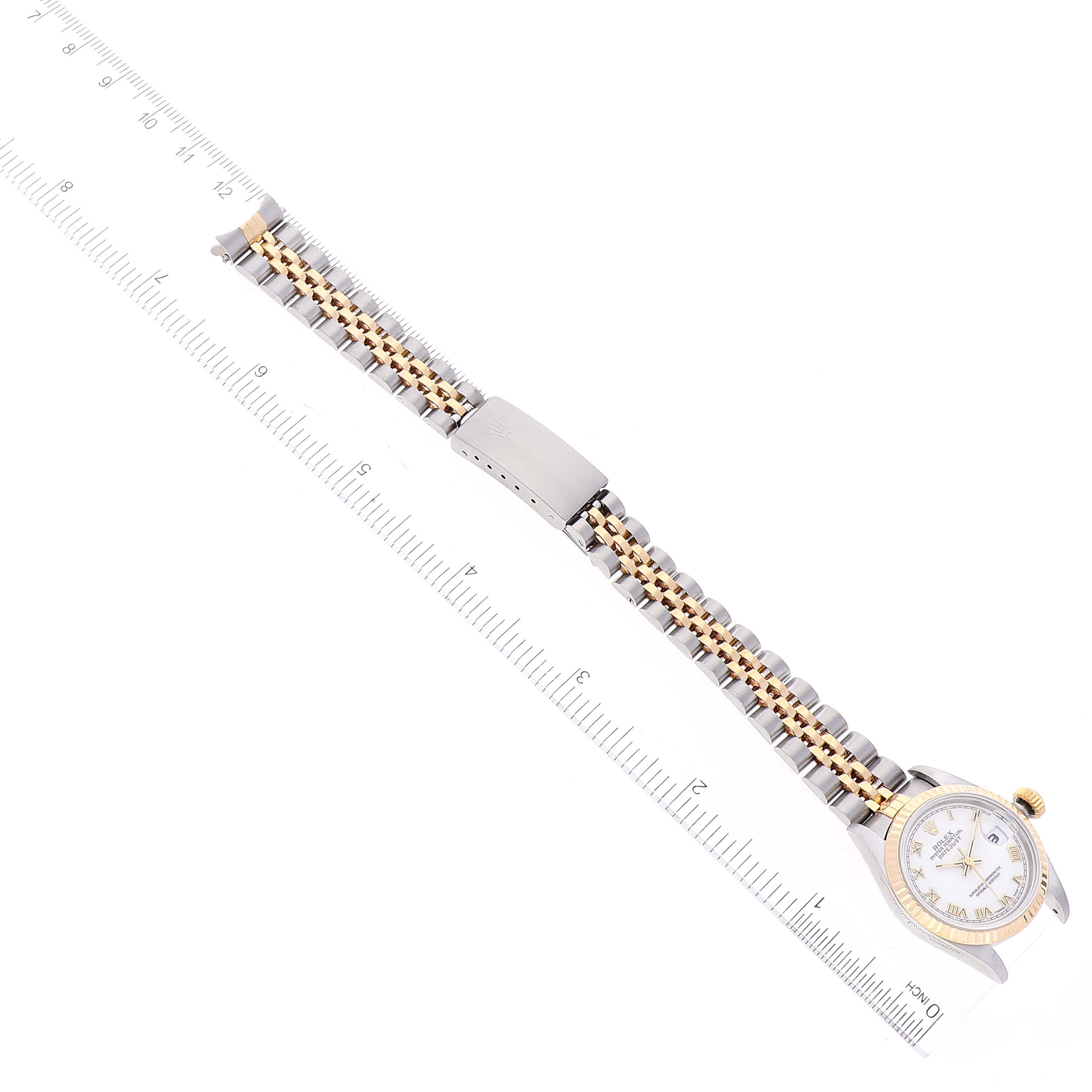 The Rolex Datejust 69173 Women
s Steel and Gold (two tone) White Dial 69173 Women
s Steel and Gold (two tone) White Dial watch is shown from a top-down angle, displaying the watch face, bezel, full bracelet, and clasp alongside a ruler.