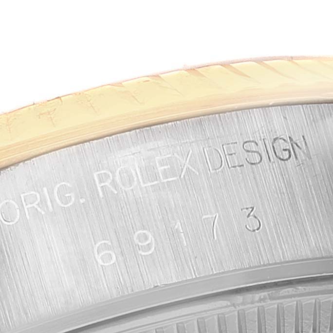 This close-up shows the bezel and case with engraving details of a Rolex Datejust 69173 Women
s Steel and Gold (two tone) White Dial 69173 Women
s Steel and Gold (two tone) White Dial watch.