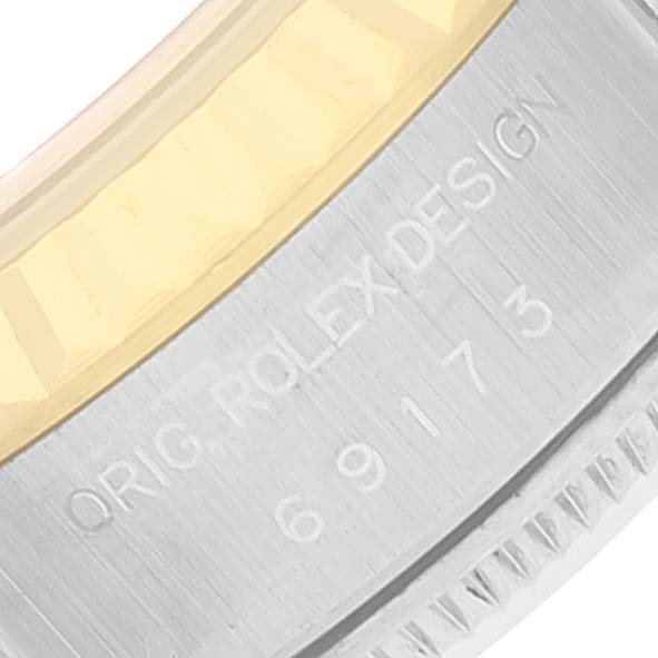 The image shows a close-up of the side of a Rolex Datejust 69173 Women's Steel and Gold (two tone) Grey Dial 69173 Women's Steel and Gold (two tone) Grey Dial watch, highlighting the bezel and engraved serial number.