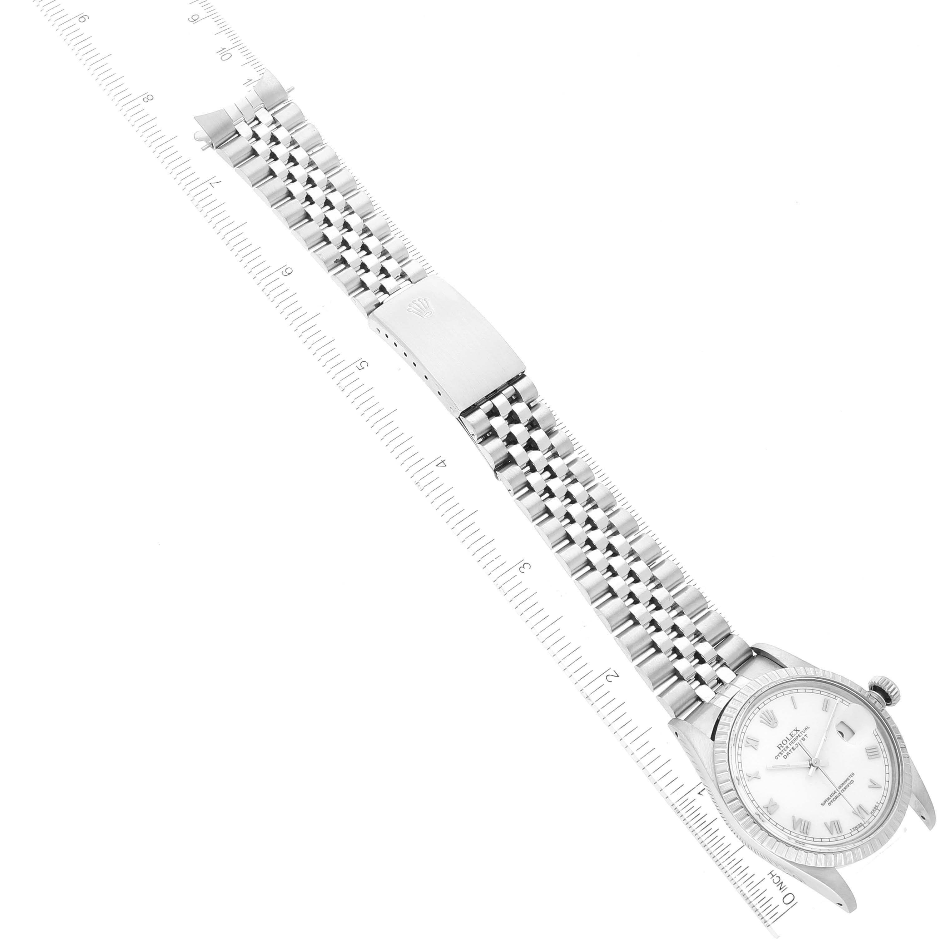 This image shows a top-down view of a Rolex Datejust 16030 Men's Stainless Steel White Dial 16030 Men's Stainless Steel White Dial watch with a focus on its face, bracelet, and clasp alongside a ruler.