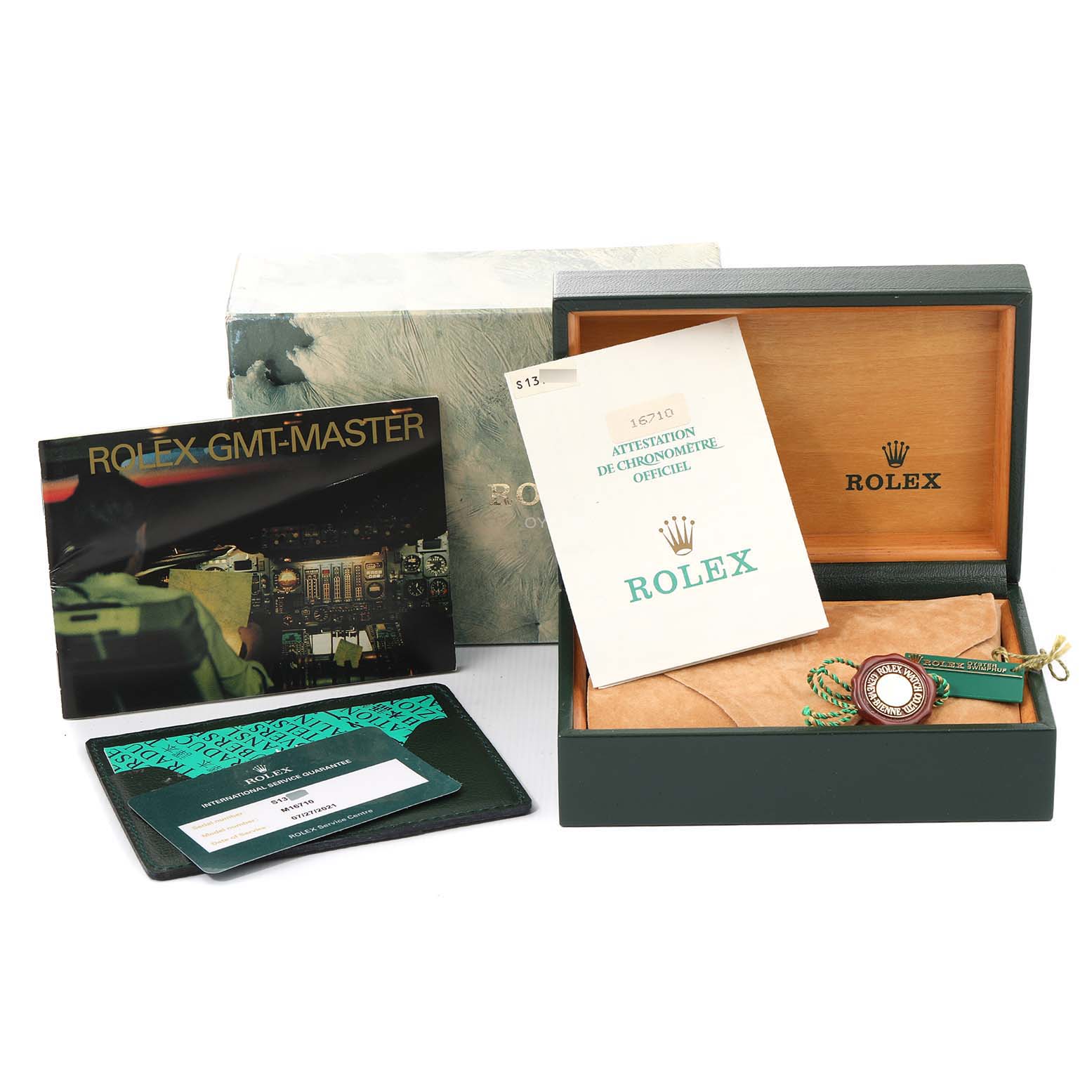 The image shows a Rolex GMT-Master 16710 Men
s Stainless Steel Black Dial 16710 Men
s Stainless Steel Black Dial watch box and accessories including an outer box, manuals, papers, and a tag.