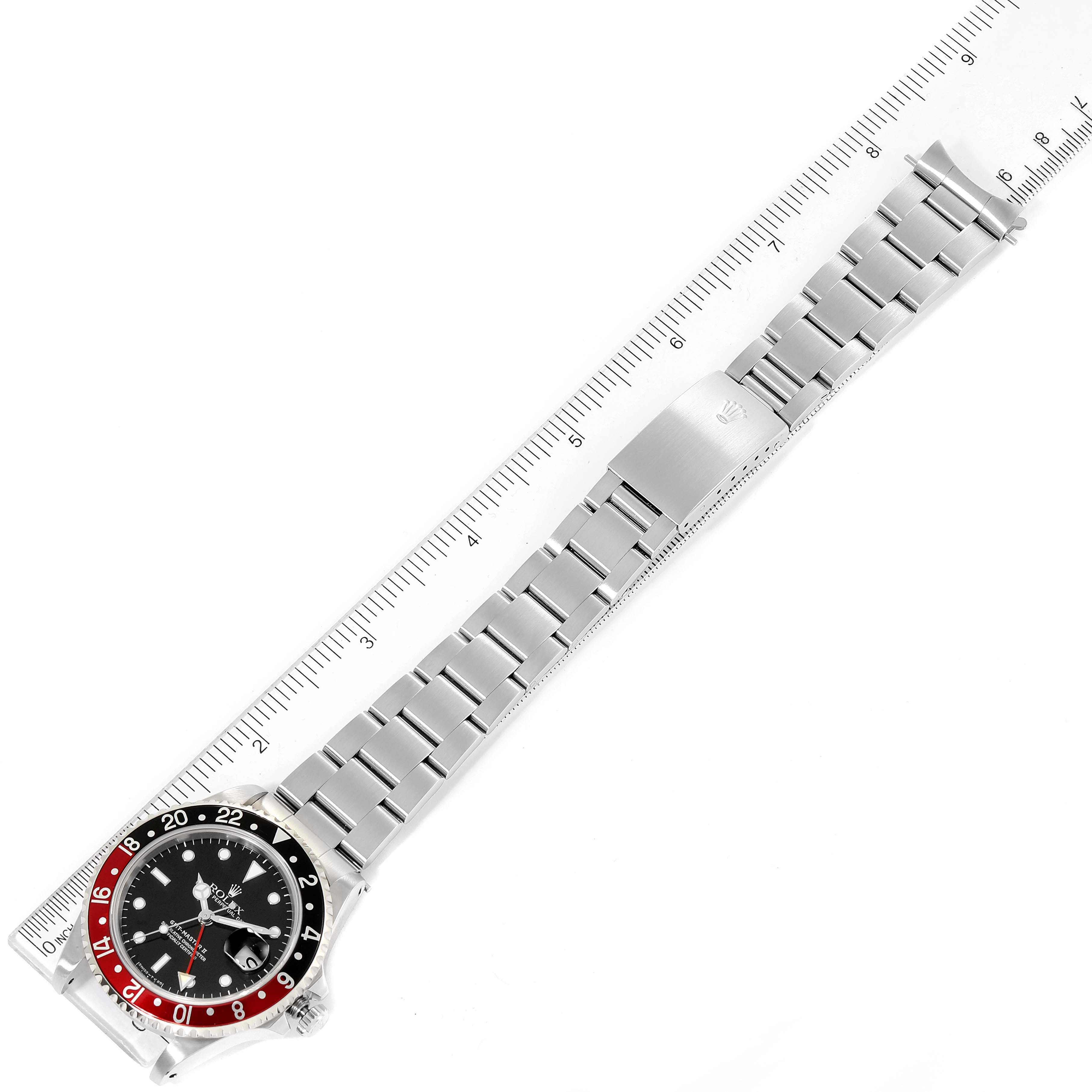 The Rolex GMT-Master 16710 Men
s Stainless Steel Black Dial 16710 Men
s Stainless Steel Black Dial watch is shown from a top-down angle, displaying the full bracelet, bezel, and dial against a ruler for scale.