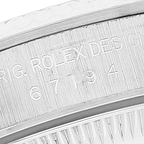 The image shows a close-up of the engraved serial number on the case edge of a Rolex Datejust 67194 Women
s Stainless Steel Silver Dial 67194 Women
s Stainless Steel Silver Dial watch.