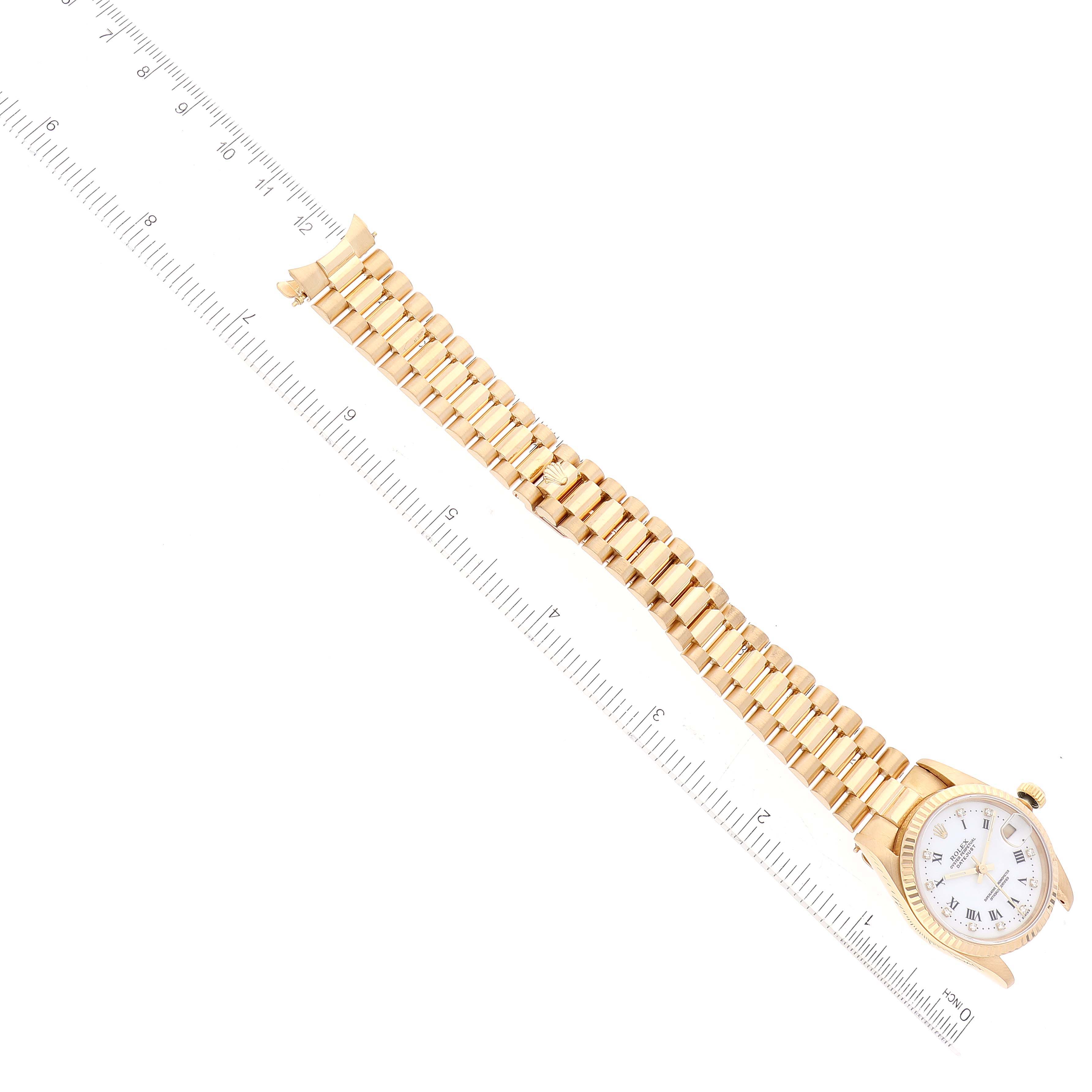 The image shows a Rolex President 68278 Women's Yellow Gold White Dial 68278 Women's Yellow Gold White Dial model watch laid flat with the band and the dial measured against a ruler.