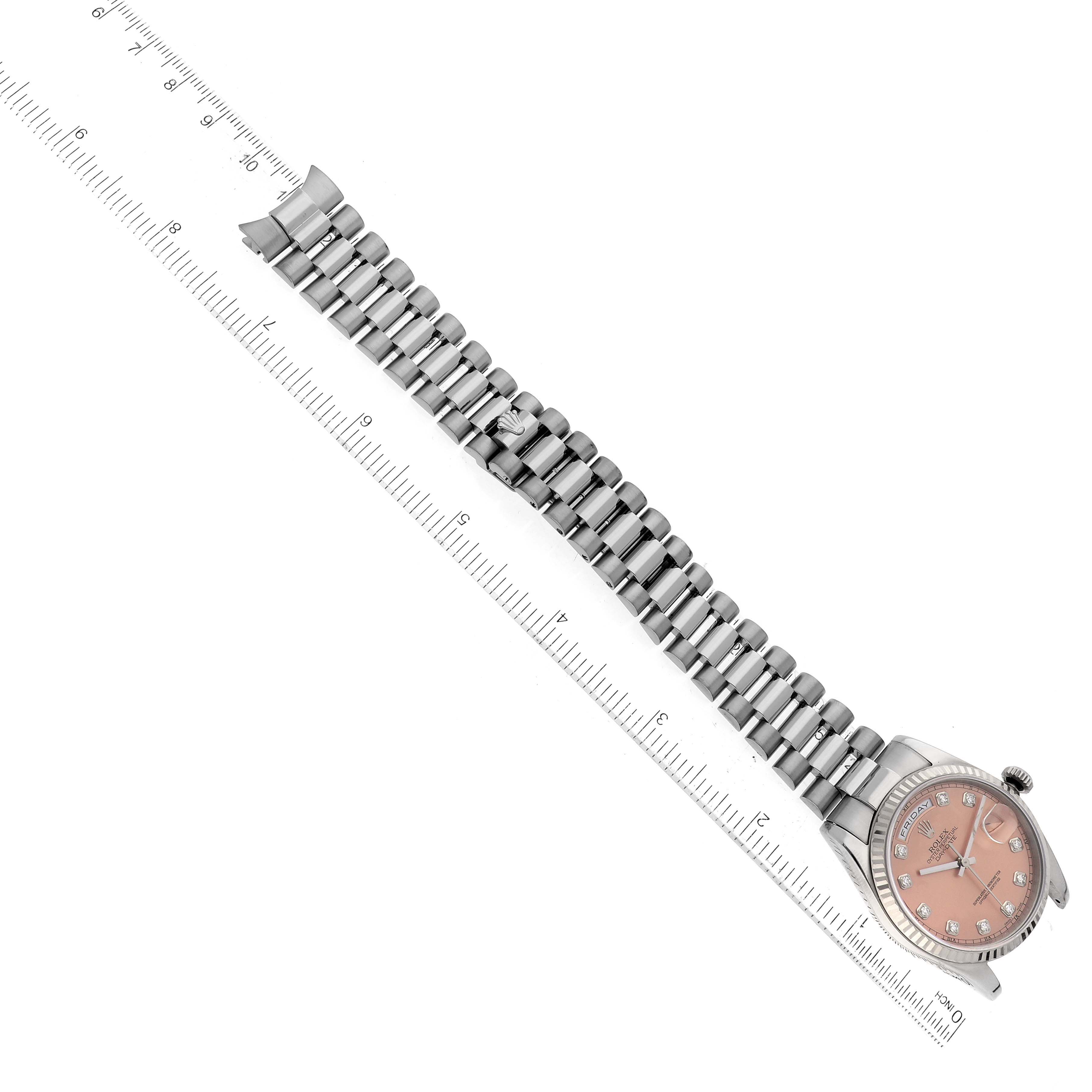 The image shows a Rolex President 118239 Men's White Gold Pink Dial 118239 Men's White Gold Pink Dial model watch with a close-up of its bracelet and face, positioned next to a ruler.