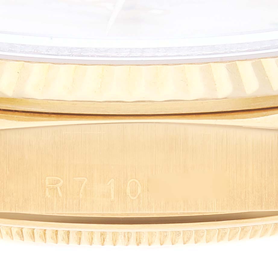This close-up image of a Rolex President 18238 Men's Yellow Gold Beige Dial 18238 Men's Yellow Gold Beige Dial watch shows the edge of the case and part of the bezel with serial number details.