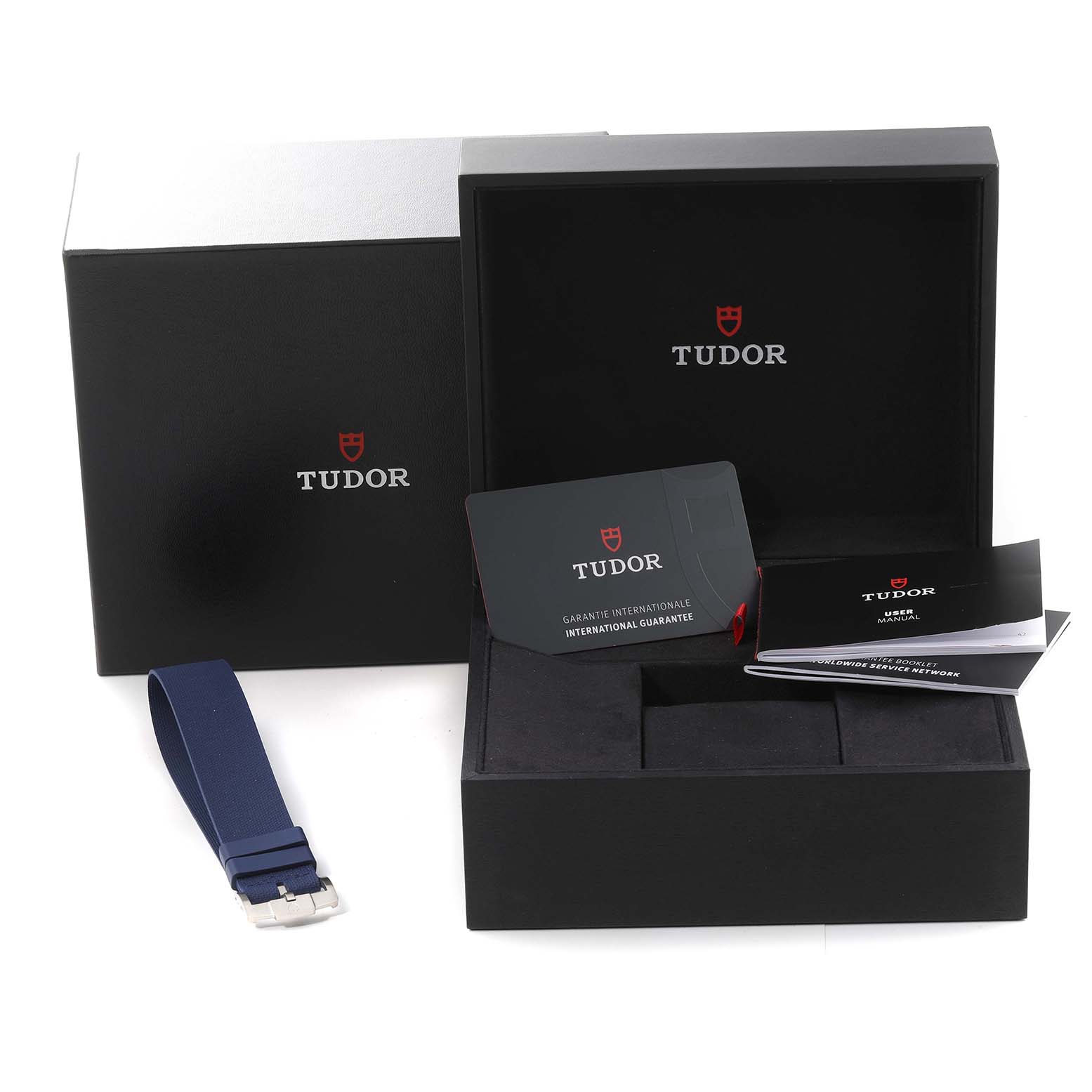 The image shows the packaging, warranty card, manuals, and an additional strap for the Tudor Pelagos 25707 Men's Titanium Blue Dial 25707 Men's Titanium Blue Dial watch.