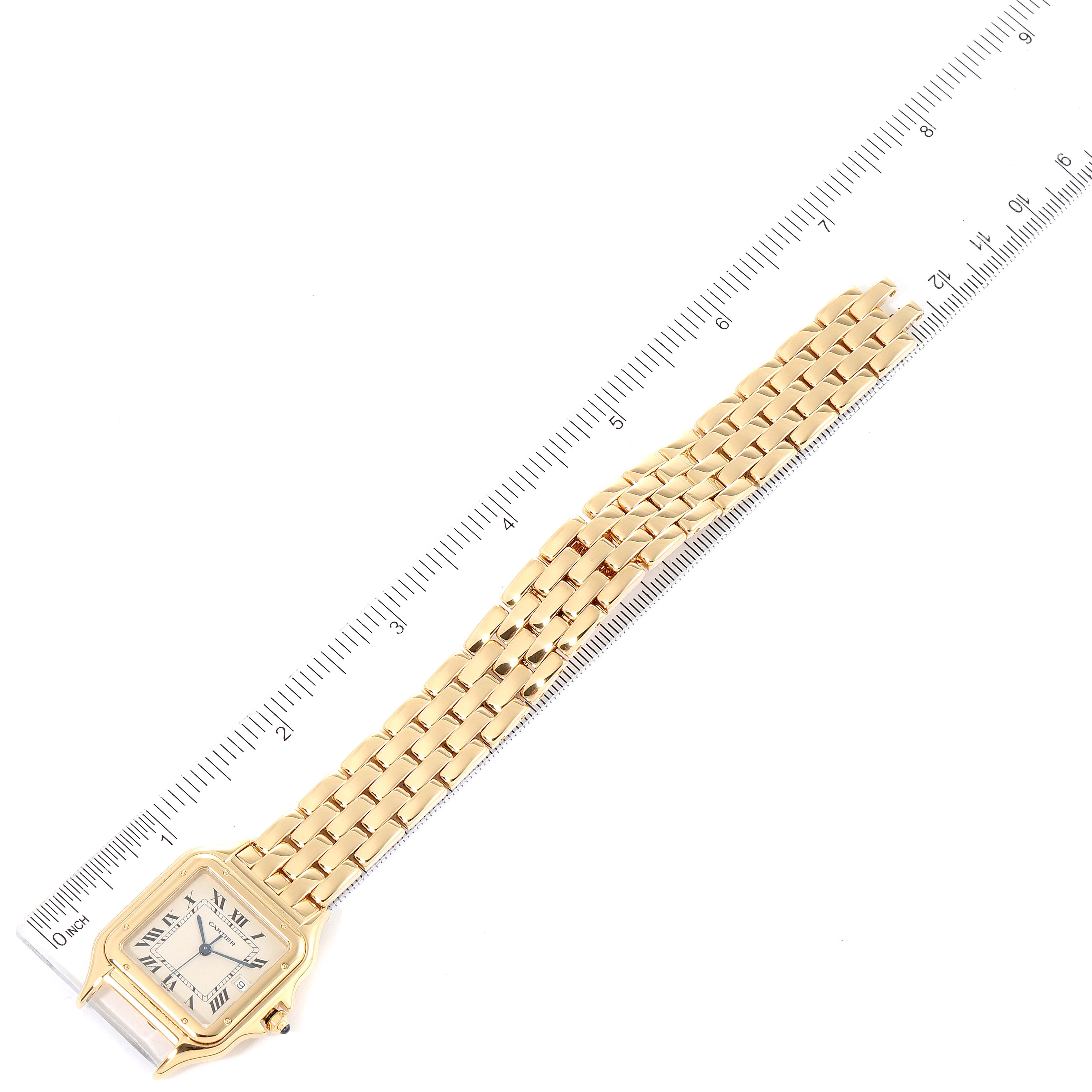 This image shows a top-down view of a Cartier Panthere W25014B9 Men's Yellow Gold Silver Dial W25014B9 Men's Yellow Gold Silver Dial watch, including its entire gold band and face, next to a ruler for size reference.