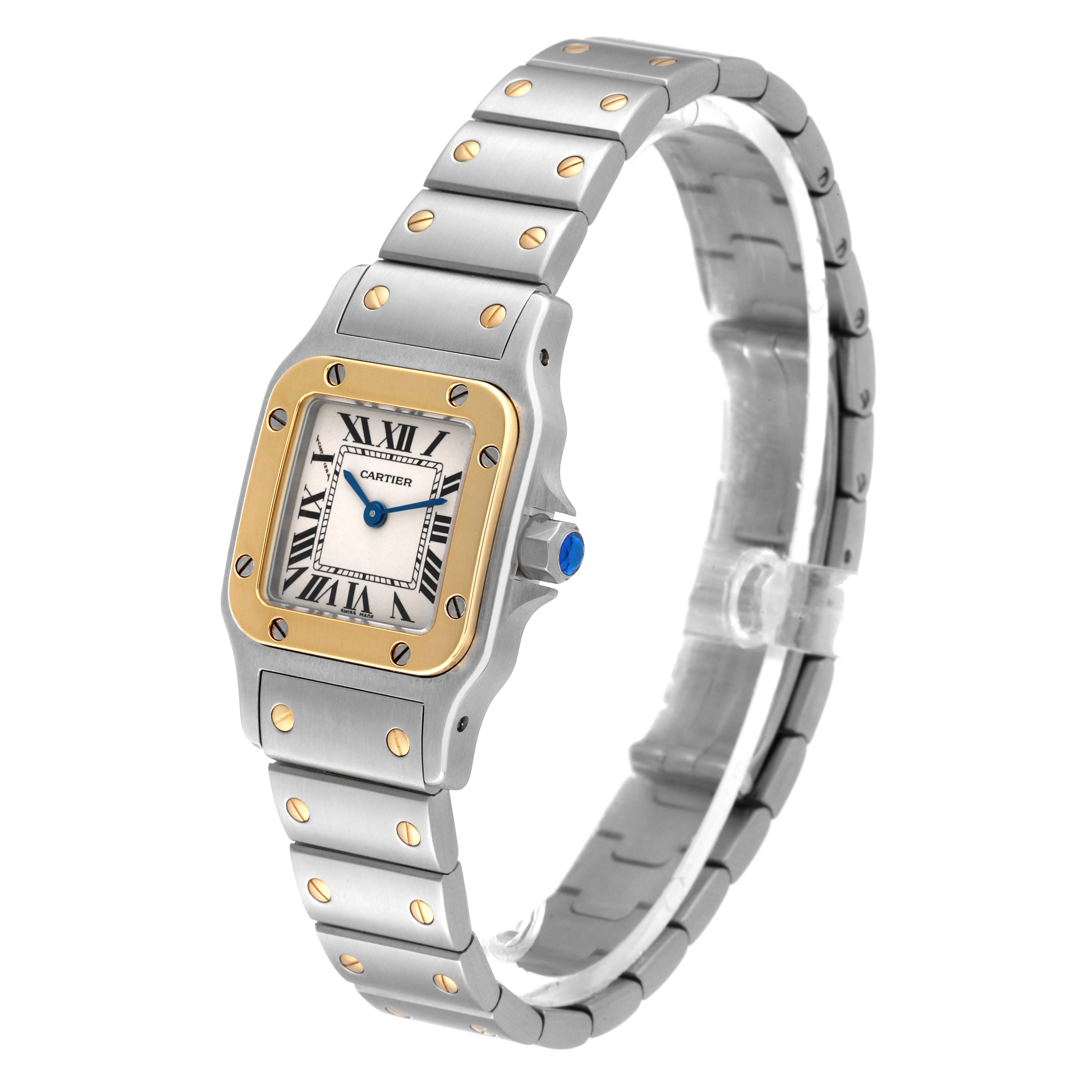 The Santos de Cartier watch is shown at an angle displaying the face, bezel, crown, and part of the bracelet.