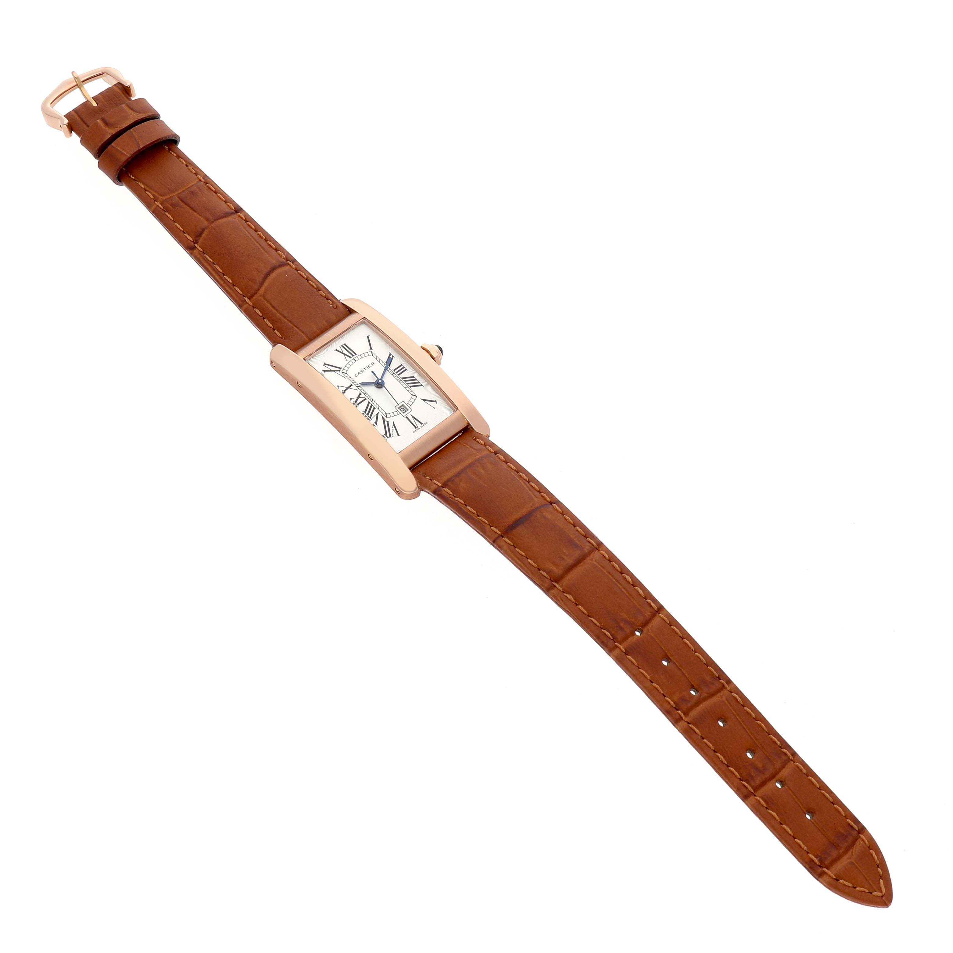 The Cartier Tank Américaine watch is shown from a top-down angle, displaying its rectangular face and brown leather strap.