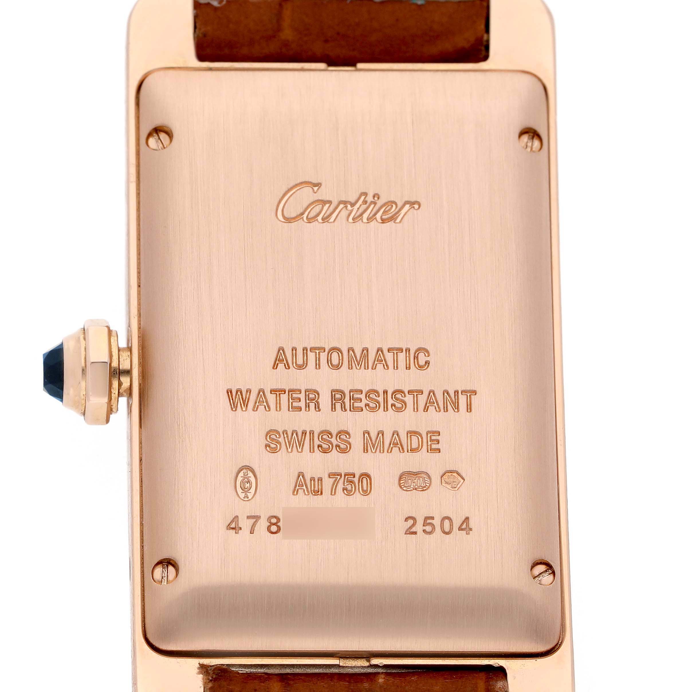 The image shows the back of the Cartier Tank Américaine watch, featuring the brand name, model details, and a sapphire crown.