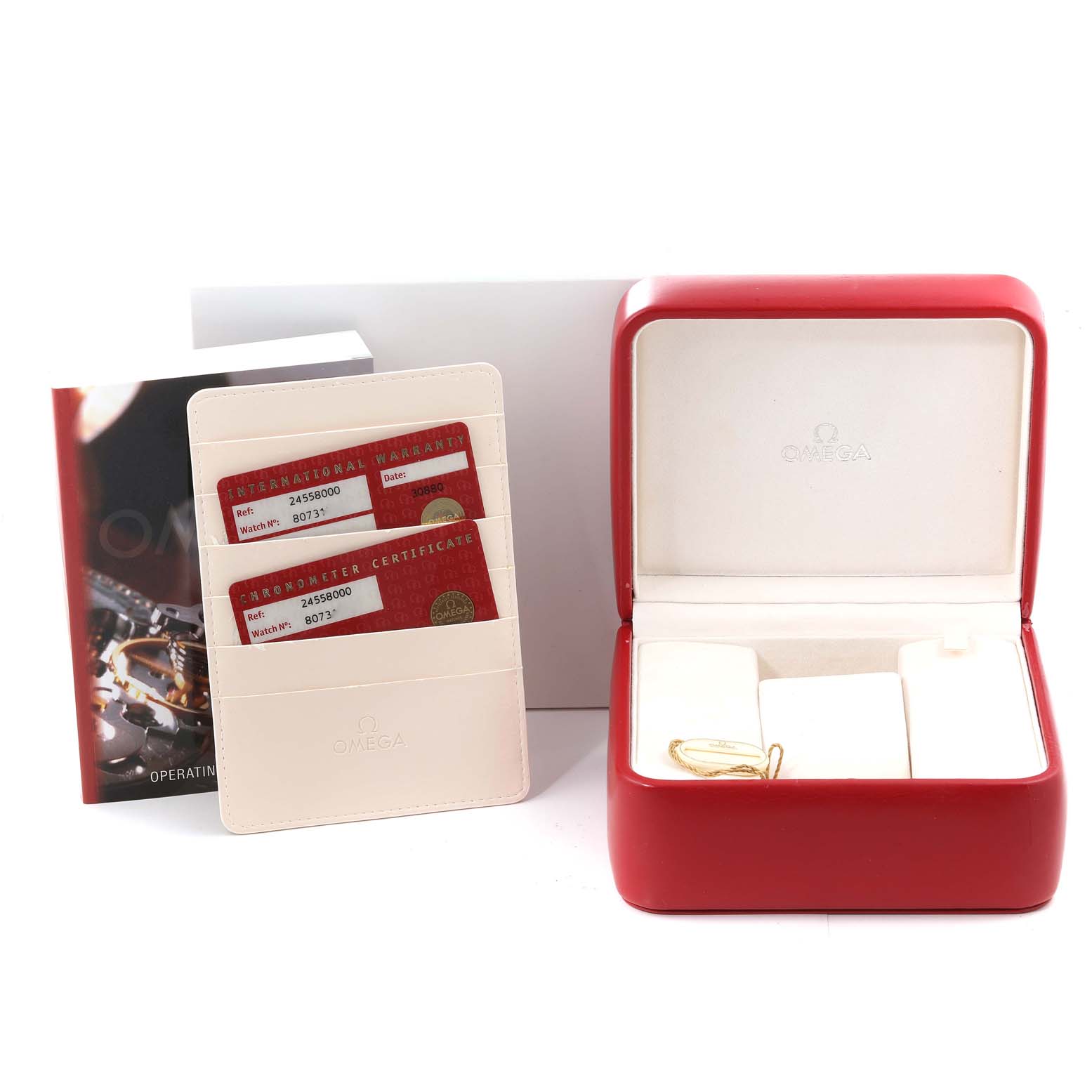 The image shows a red Omega watch box, a warranty cardholder, certificates, and the operating instructions for the Seamaster model.