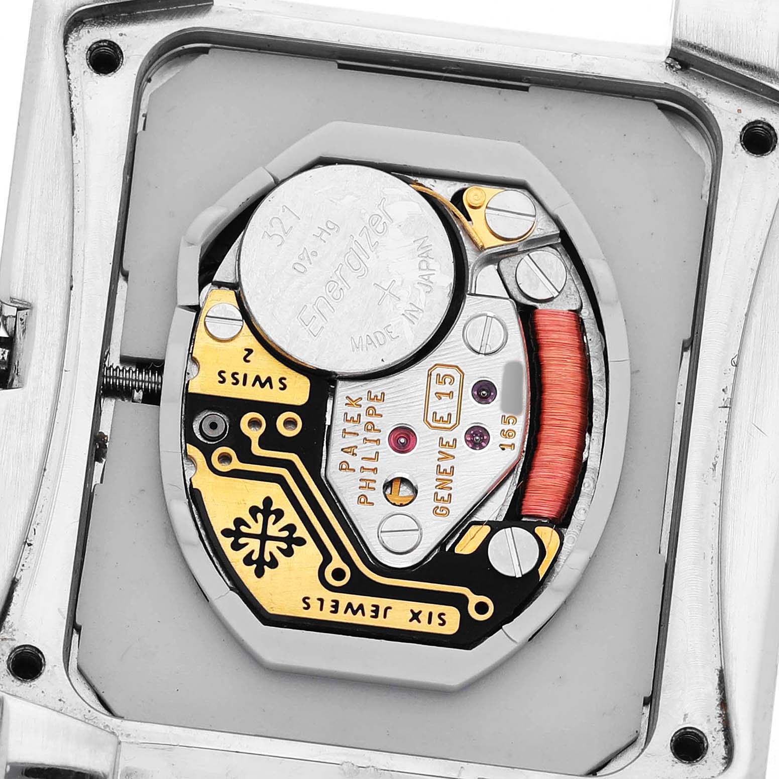 The image shows the movement of a Patek Philippe Twenty-4 4910/10A Women's Stainless Steel Black Dial watch from a back angle, revealing its battery and internal components.