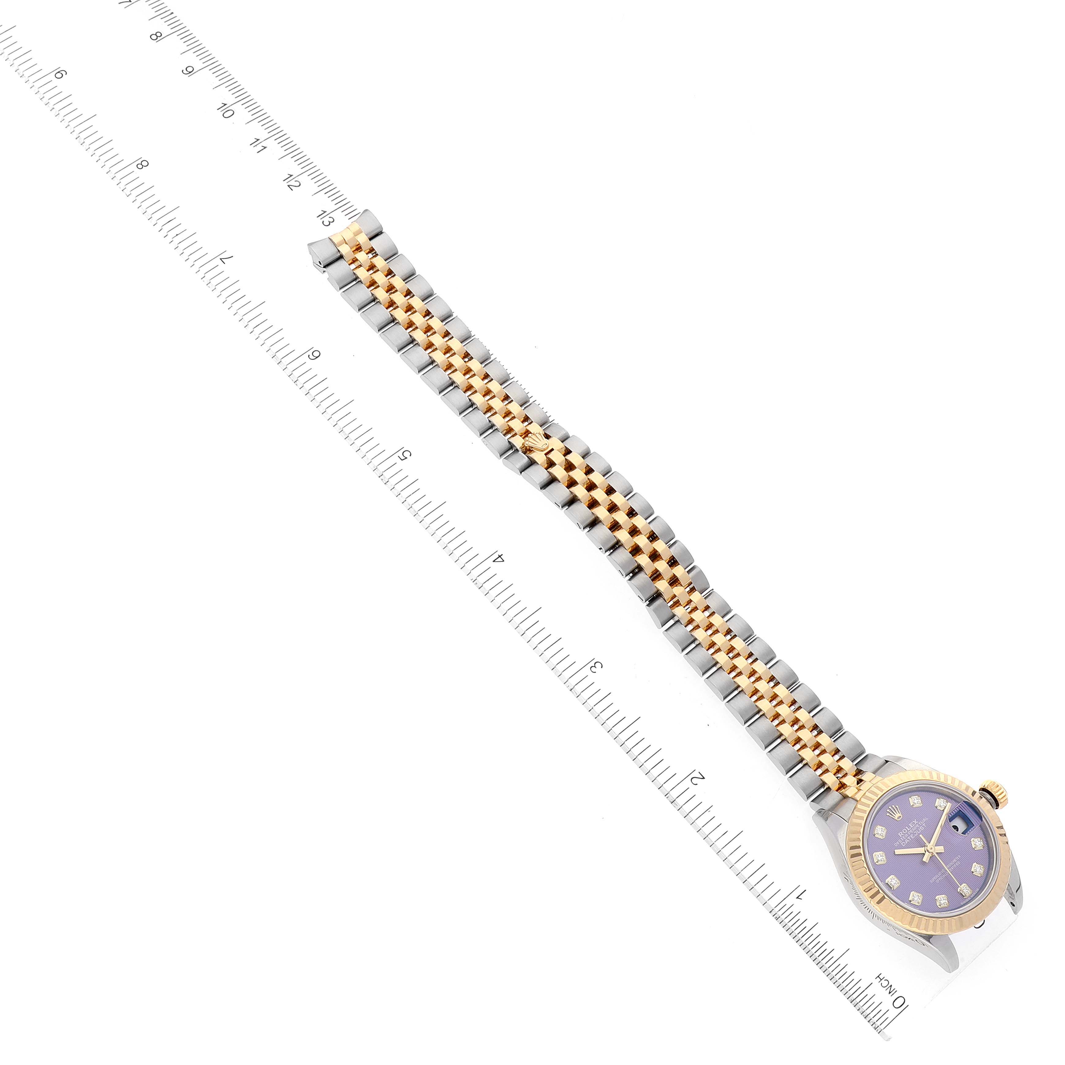 The Rolex Datejust 279173 Women's Steel and Gold (two tone) Purple Dial 279173 Women's Steel and Gold (two tone) Purple Dial watch is photographed from an angled top view, showing its dial, bezel, and full bracelet alongside a ruler for scale.
