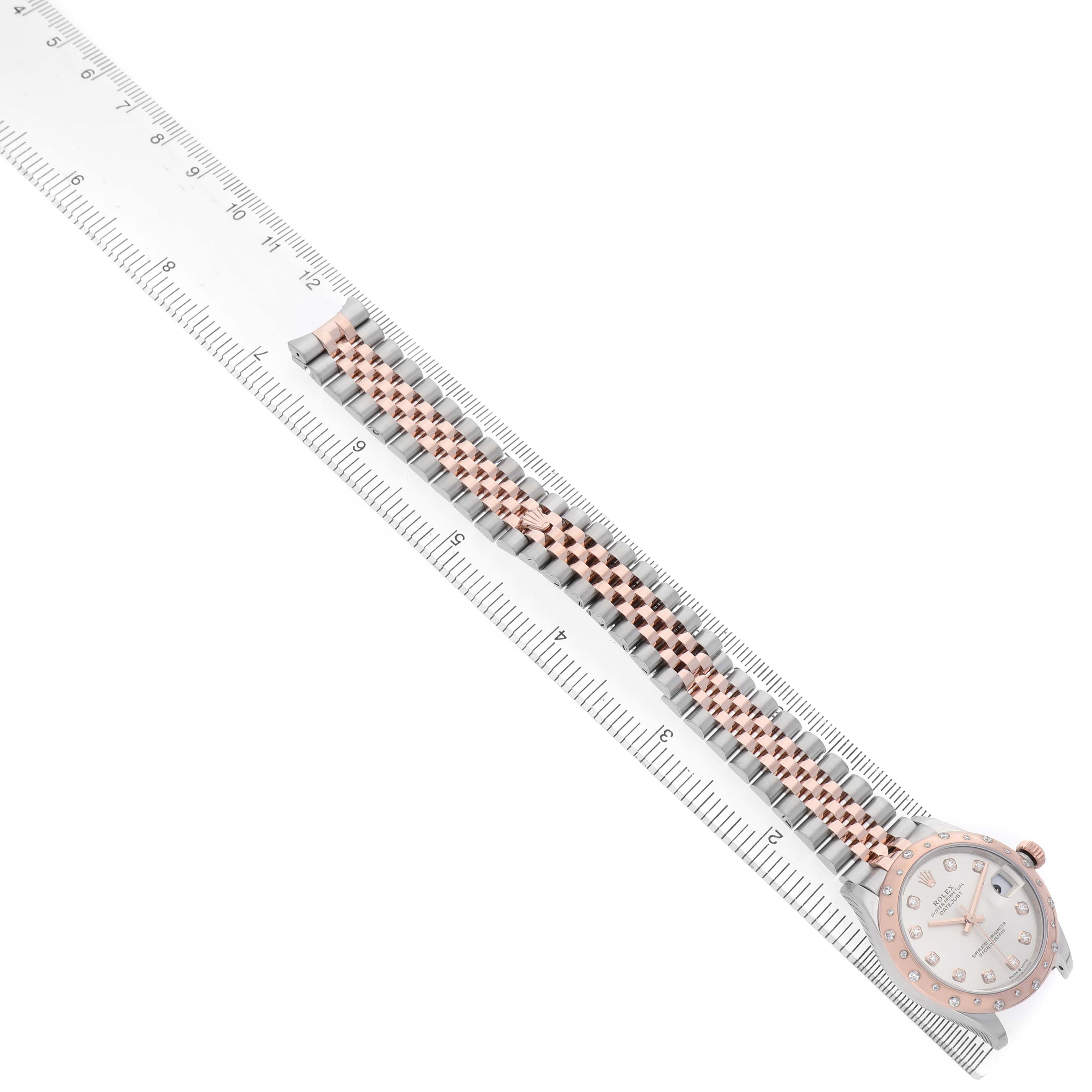 The Rolex Mid-Size 278341 Women's Steel and Gold (two tone) Silver Dial watch is displayed from an overhead angle, showing the face and entire strap alongside a ruler for scale.
