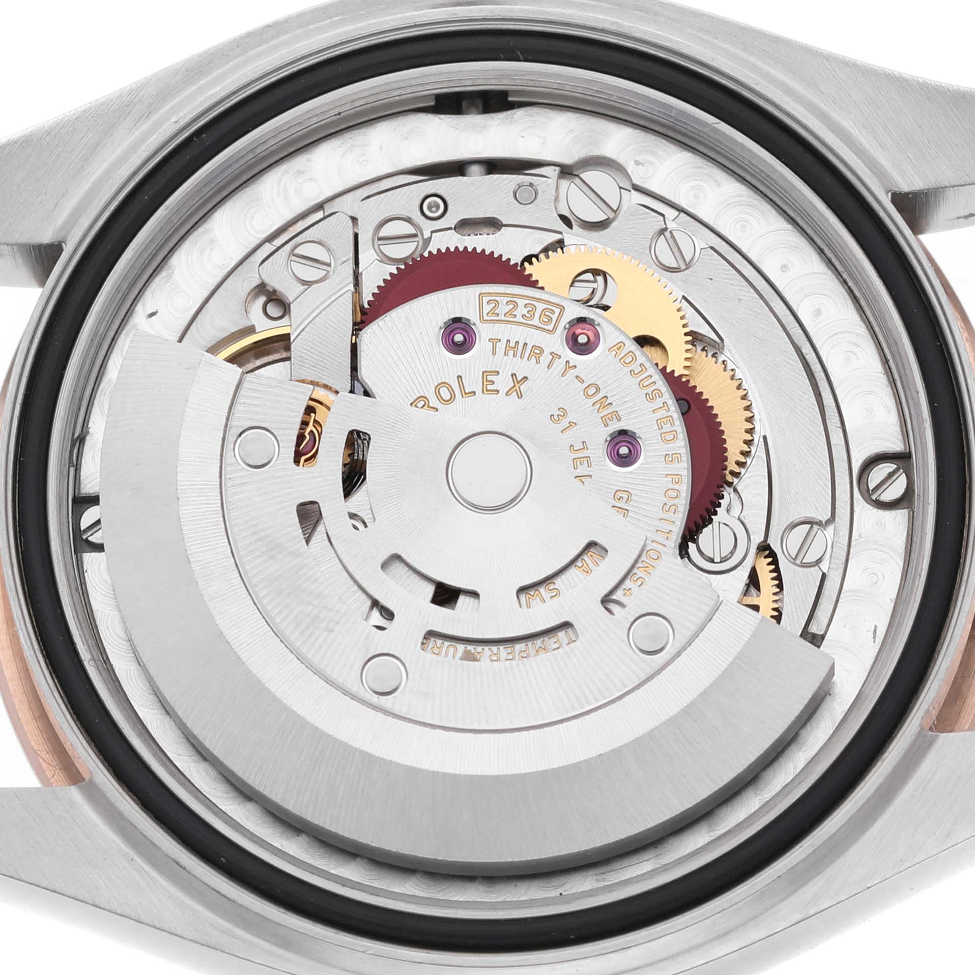 The image shows the movement of a Rolex Mid-Size 278271 Women's Rose Gold White Dial watch from the back, highlighting its gears and internal components.