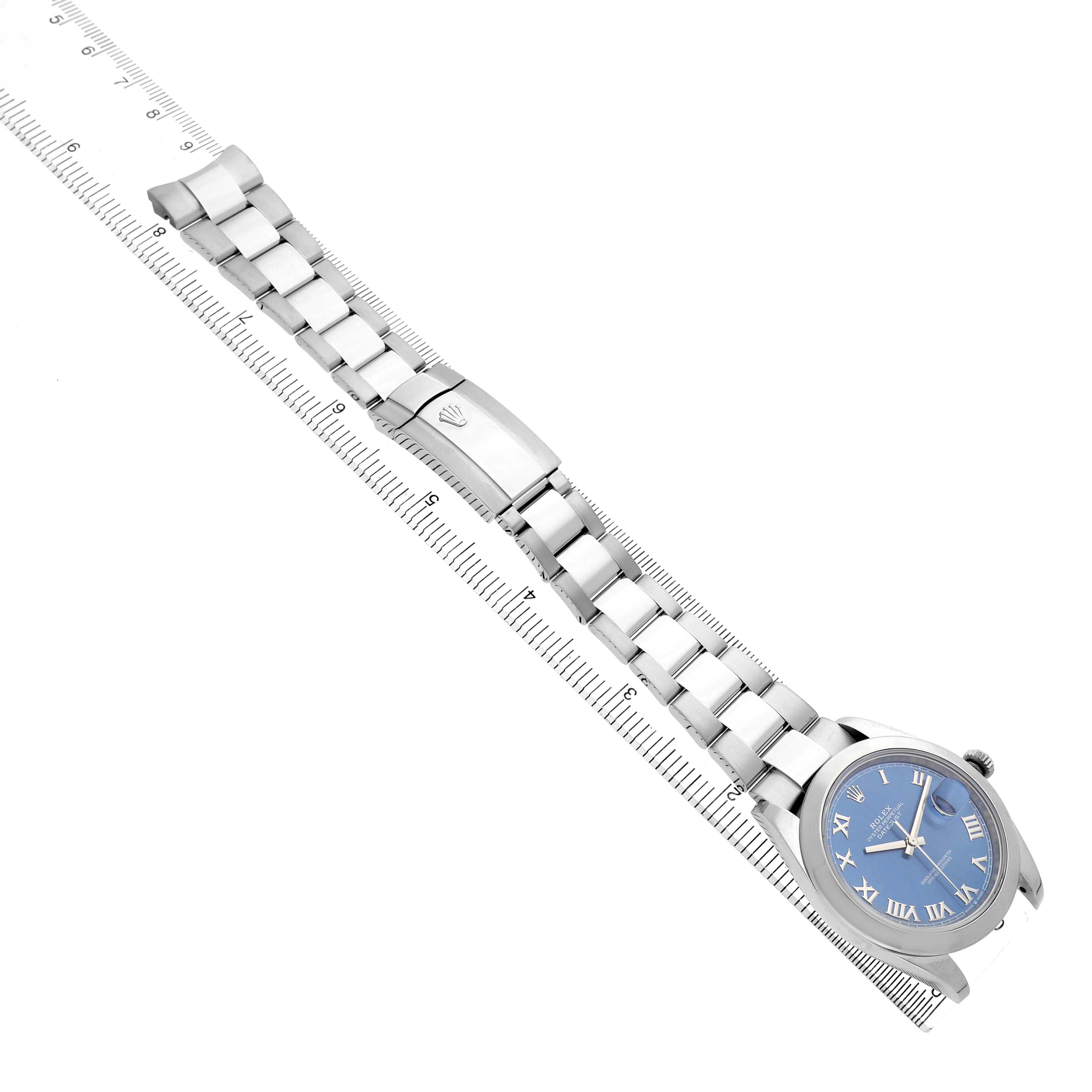 The Rolex Datejust 41 126300 Men's Stainless Steel Blue Dial is shown from an angled top view, displaying the full watch and bracelet beside a ruler.