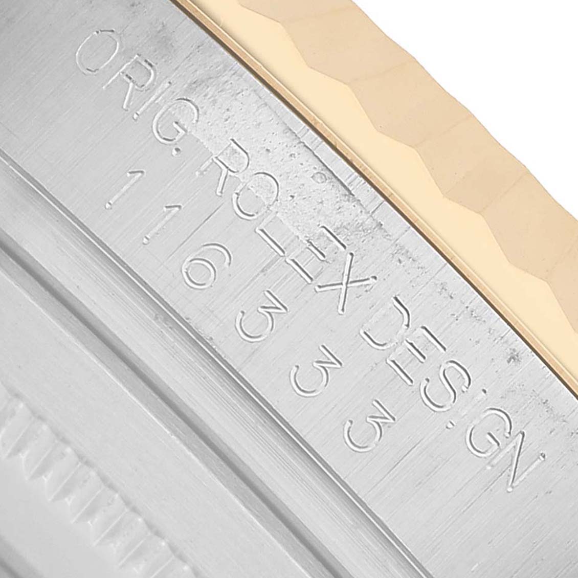 This image shows a close-up of the engraved case side of a Rolex Datejust 41 116333 Men's Steel and Gold (two tone) Black Dial, highlighting the model number and design markings.