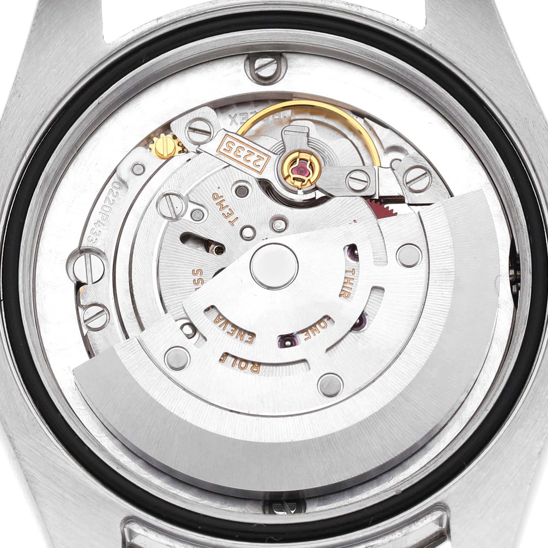 The image shows the movement of a Rolex Mid-Size 178274 Women's Stainless Steel Black Dial watch from a rear angle, highlighting its intricate mechanics and rotor.