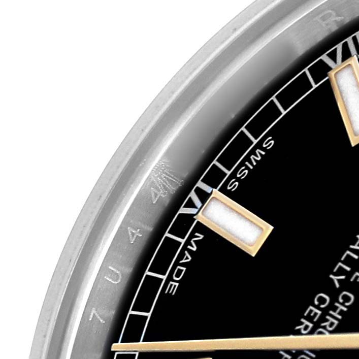 The image shows a close-up of the dial and bezel of a Rolex Mid-Size 178273 Women's Steel and Gold (two tone) Black Dial watch, revealing part of the watch face and markers.