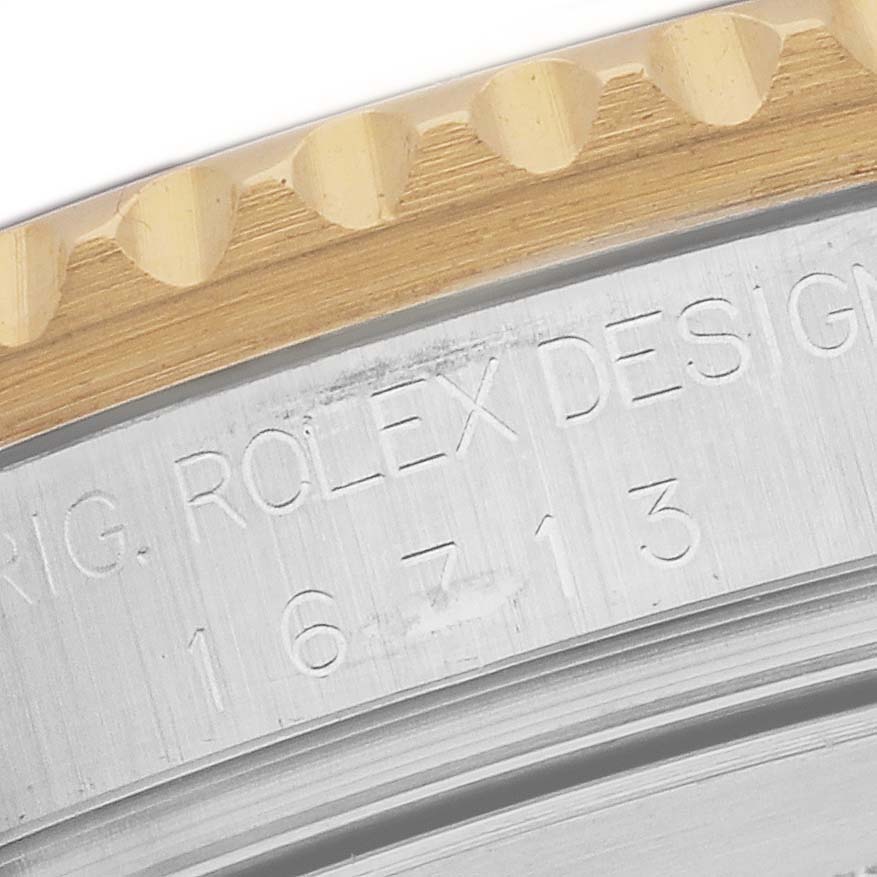 The image shows a close-up of the bezel and engraved serial number on a Rolex GMT-Master 16713 Men's Steel and Gold (two tone) Champagne Dial 16713 Men's Steel and Gold (two tone) Champagne Dial watch.