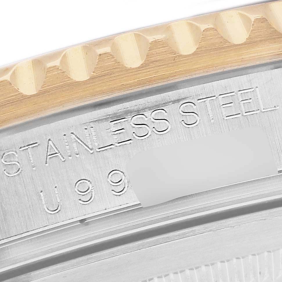 This image shows a close-up of the case back and part of the bezel of the Rolex GMT-Master 16713 Men's Steel and Gold (two tone) Champagne Dial 16713 Men's Steel and Gold (two tone) Champagne Dial, highlighting the "STAINLESS STEEL" engraving.