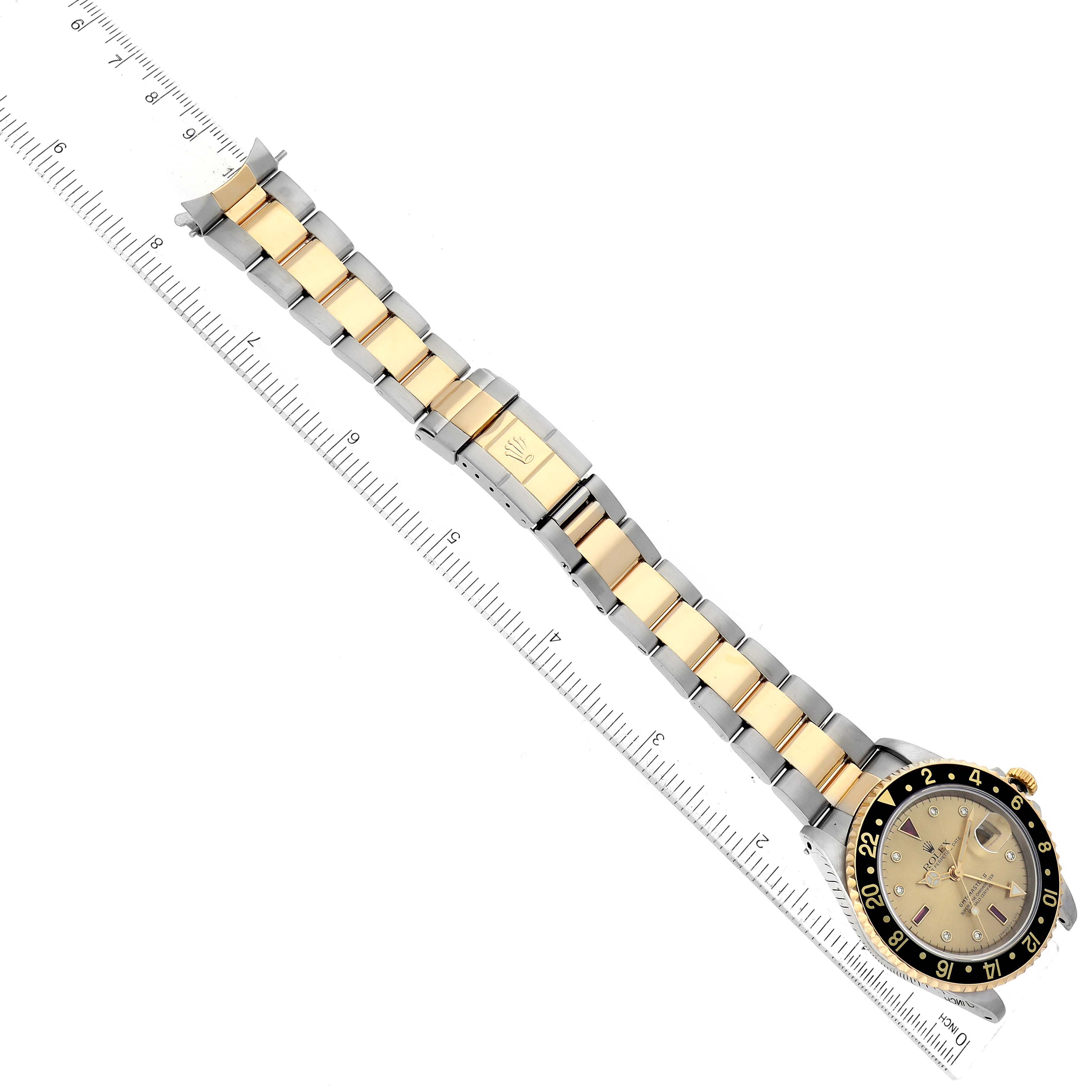 The image shows a Rolex GMT-Master 16713 Men's Steel and Gold (two tone) Champagne Dial 16713 Men's Steel and Gold (two tone) Champagne Dial watch laid flat with its bracelet extended along a ruler.