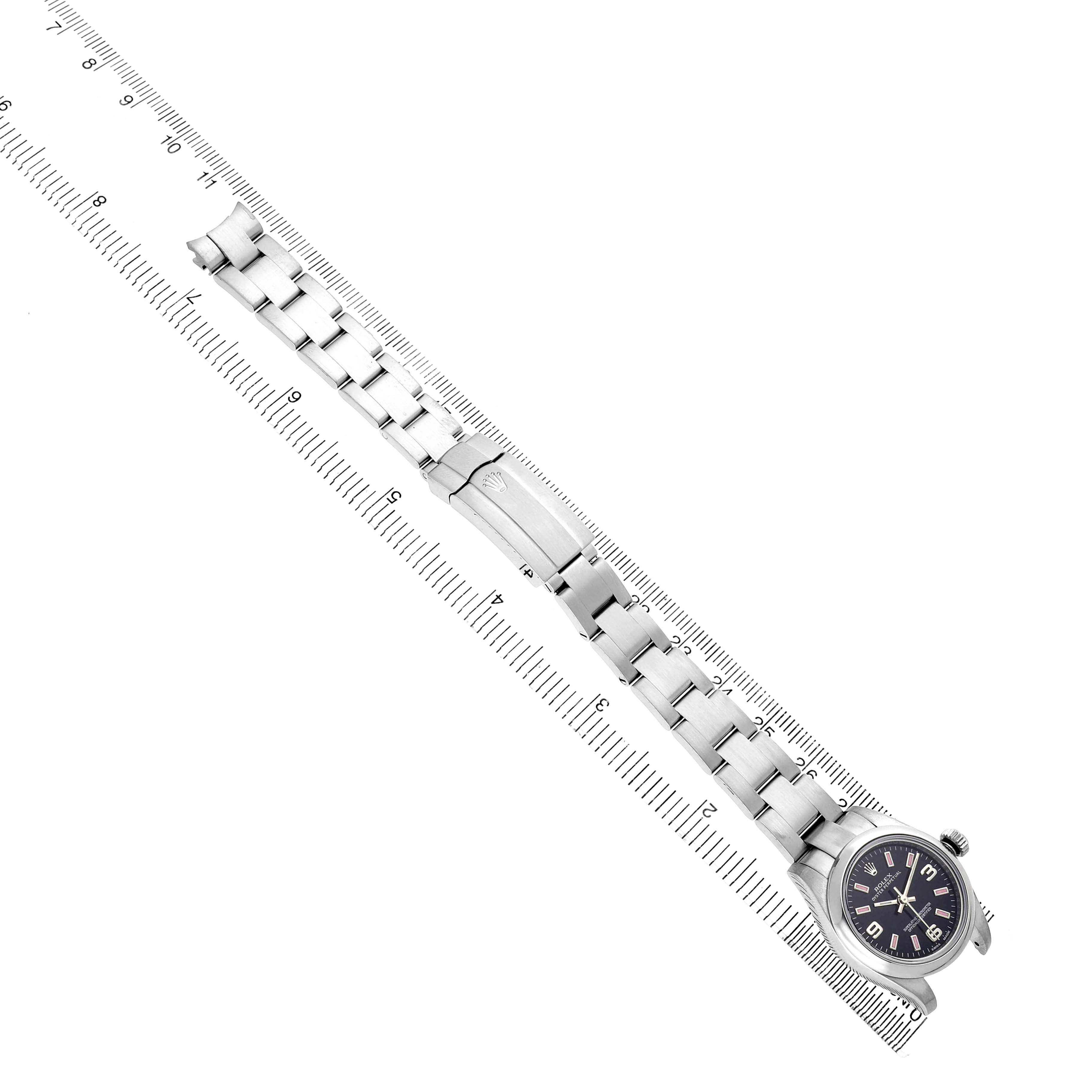 The Rolex Oyster Perpetual 176200 Women's Stainless Steel Black Dial is shown from above, highlighting the watch face and full bracelet against a ruler.