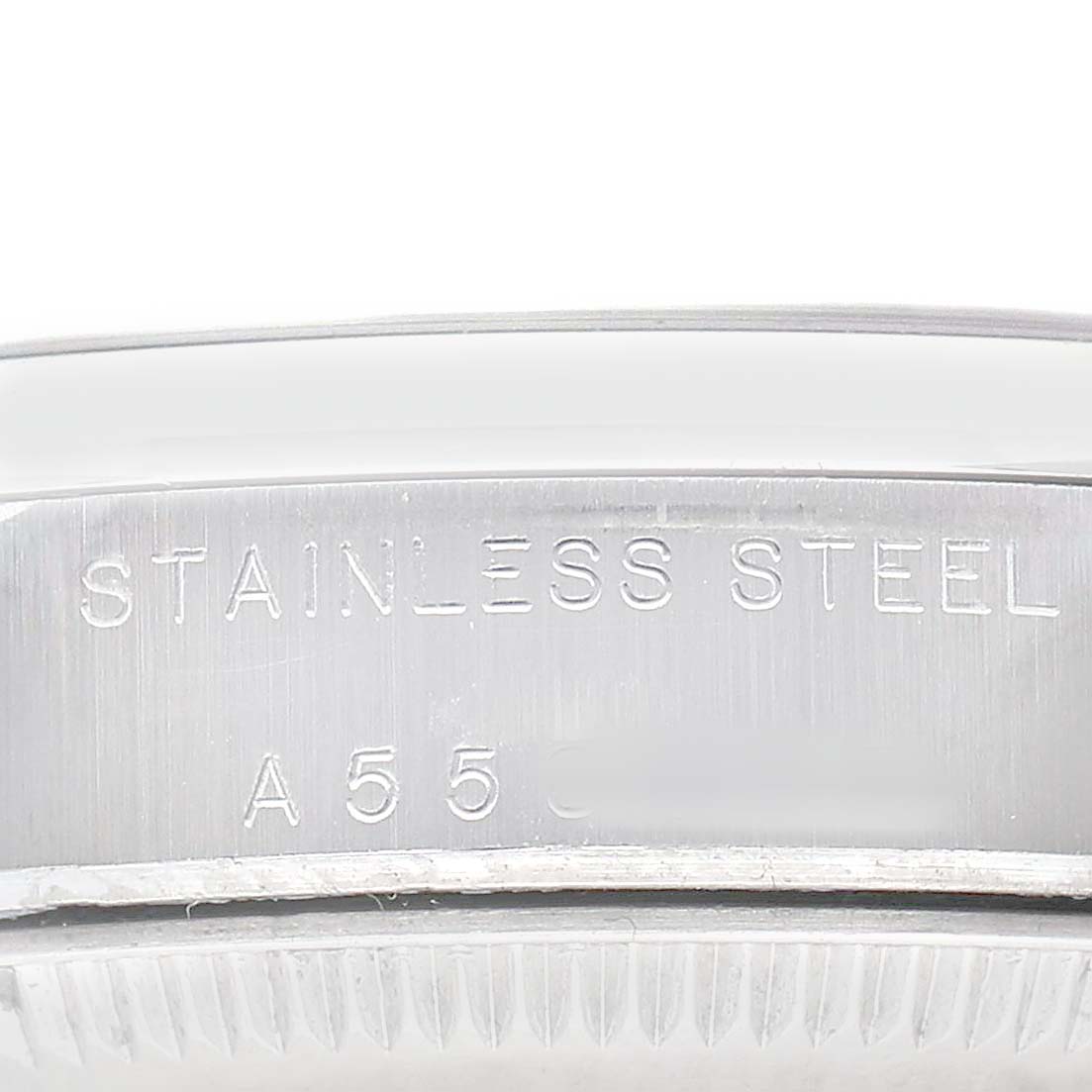 The image shows a side view of the stainless steel case of a Rolex Mid-Size 77080 Women's Stainless Steel Blue Dial watch with engraved text.