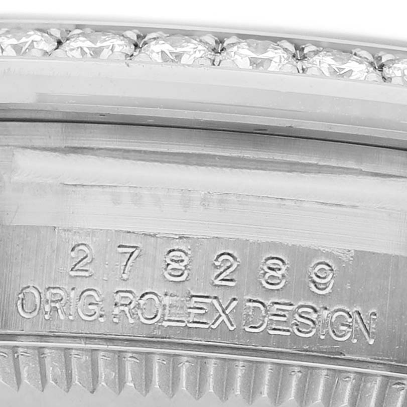 The image shows a close-up of the engraved watch case of a Rolex President 278289 Women's White Gold Blue Dial, highlighting the serial number and diamond-set bezel.