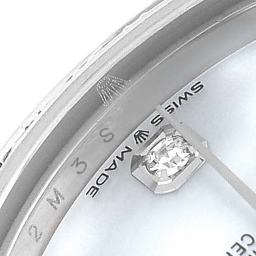 The image shows a close-up of the watch face and bezel of a Mid-Size Rolex, highlighting a gemstone and the "Swiss Made" label.