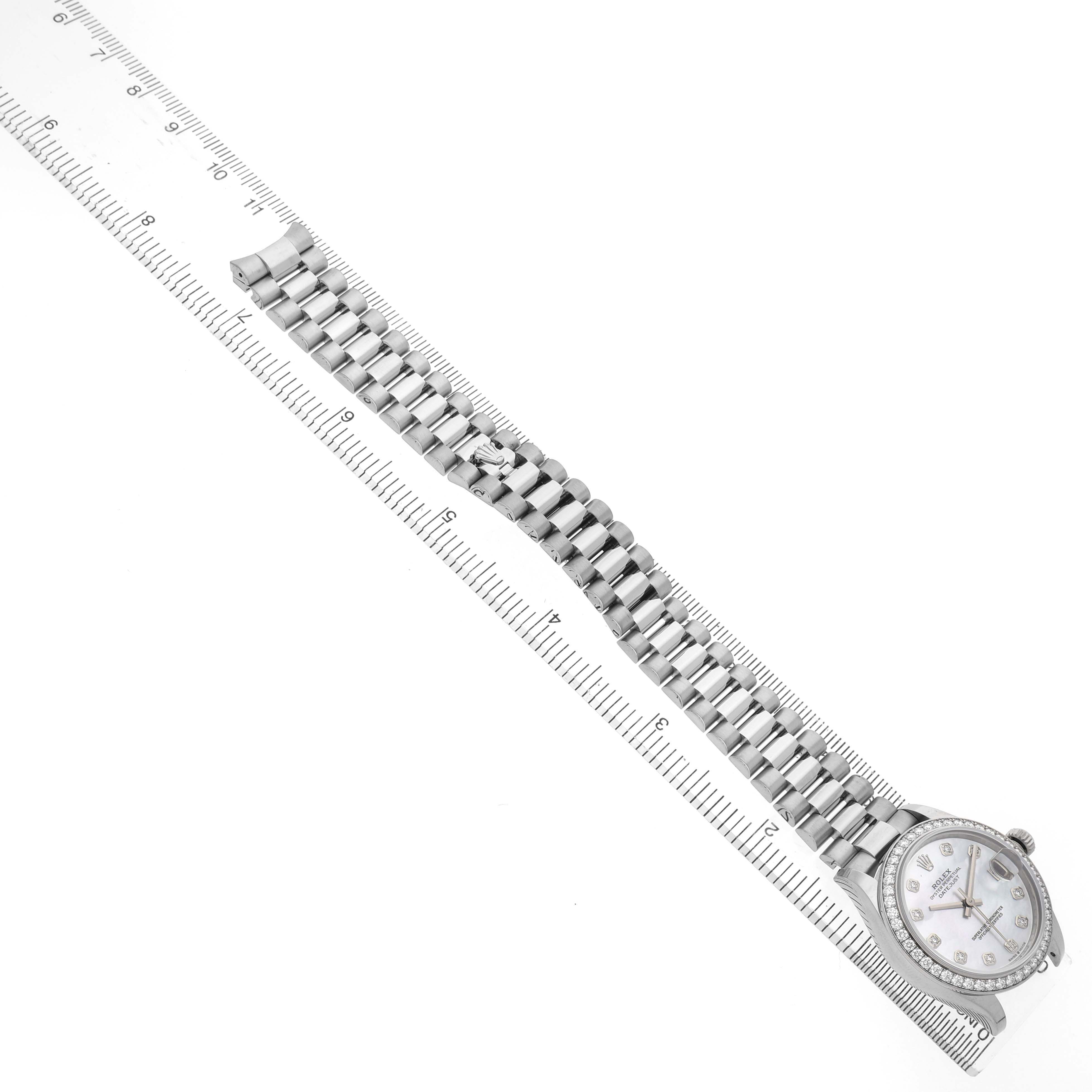 The Rolex Mid-Size 278289 Women's White Gold Mother of Pearl Dial model is shown from a top-down angle, featuring the full bracelet and dial with a ruler for scale.