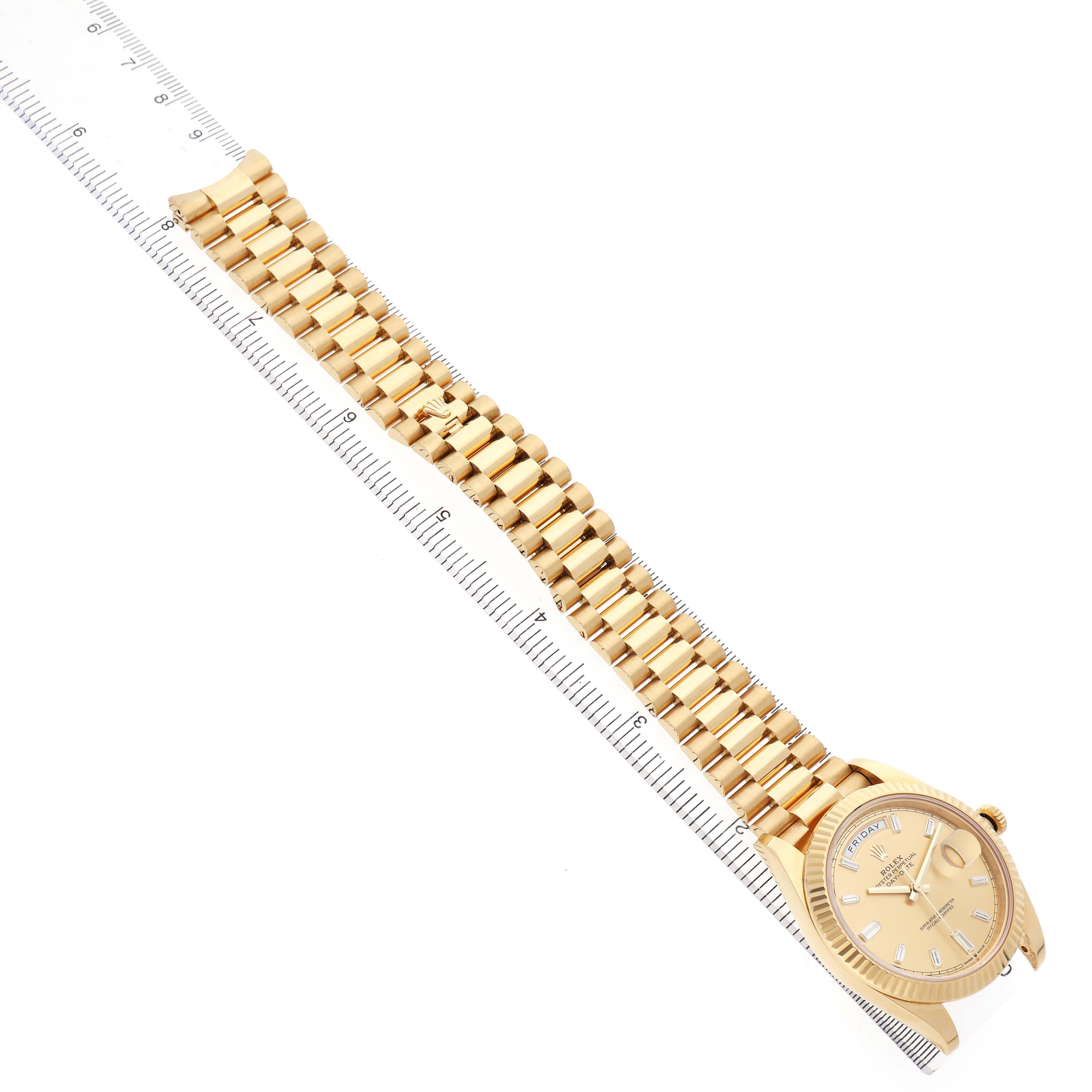 The Rolex President 228238 Men's Yellow Gold Champagne Dial watch is shown from a top view, displaying the face, bracelet, and a ruler alongside for scale.