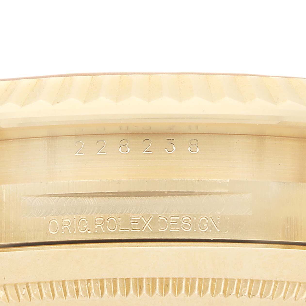 This image shows a close-up of the side of a Rolex President 228238 Men's Yellow Gold Champagne Dial model, highlighting the engraved model number and design text.