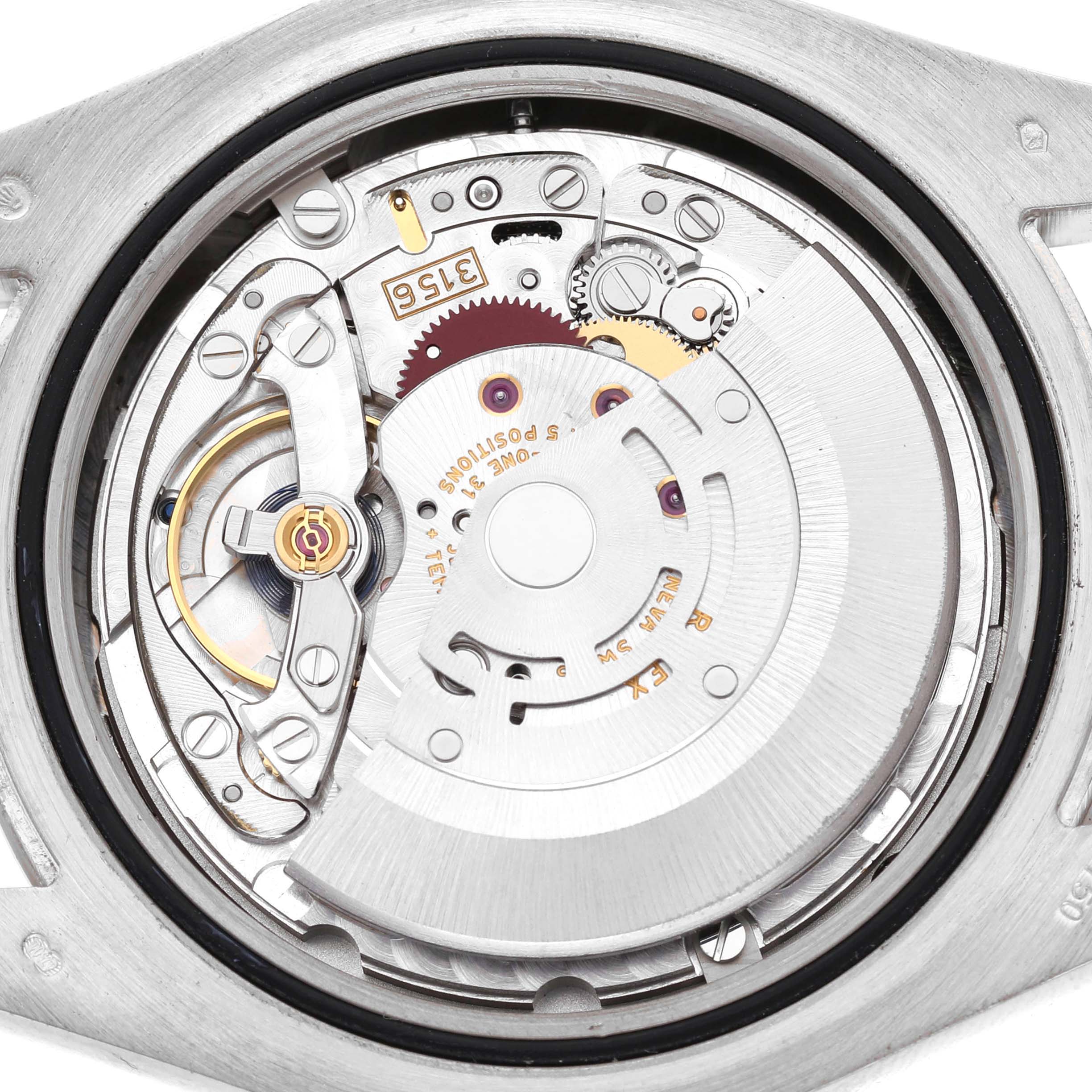 The image shows a close-up view of the movement inside the Rolex President 218239 Men's White Gold Silver Dial watch, highlighting gears and the rotor.
