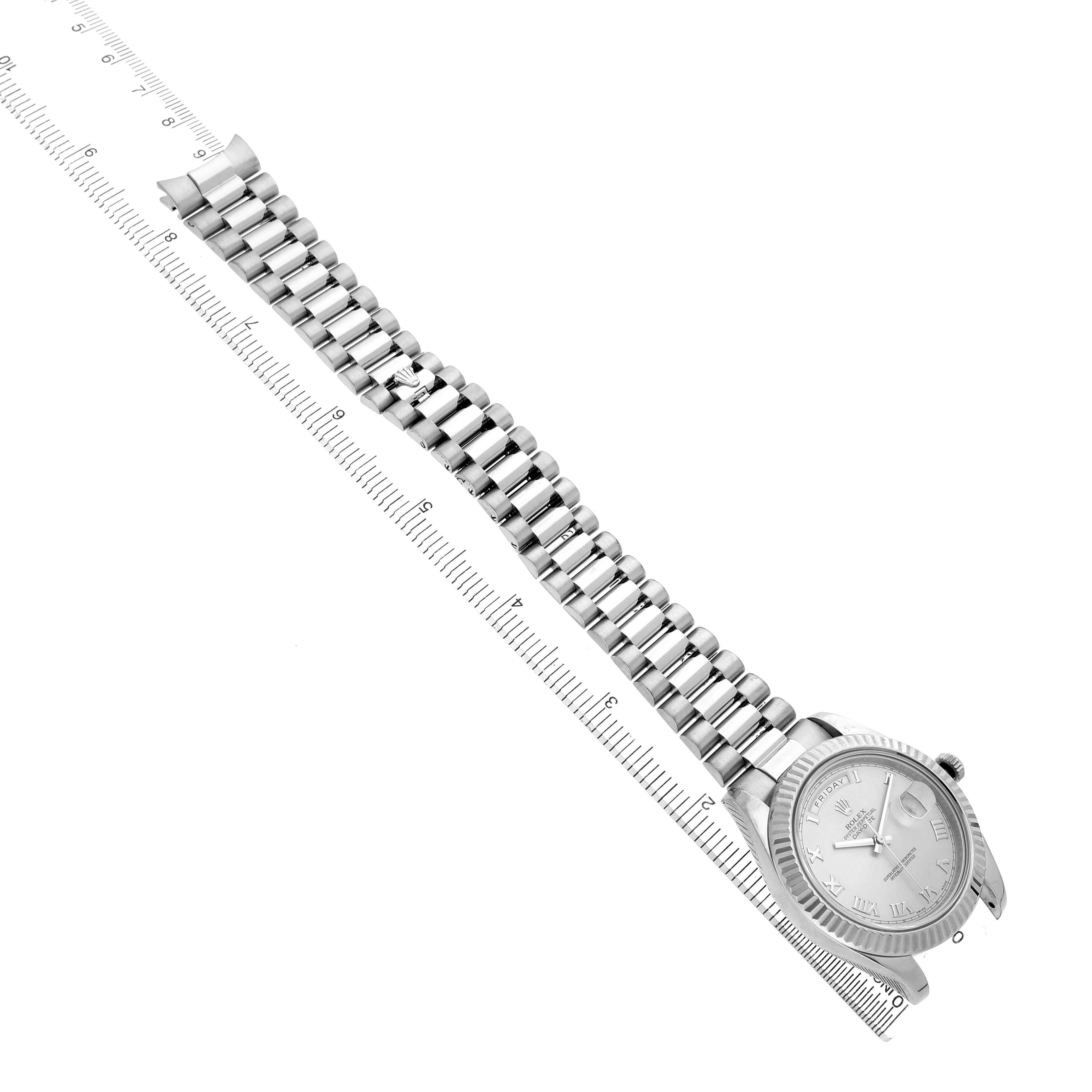 The Rolex President 218239 Men's White Gold Silver Dial watch is shown from an overhead angle, displaying the entire bracelet and watch face with a ruler alongside.