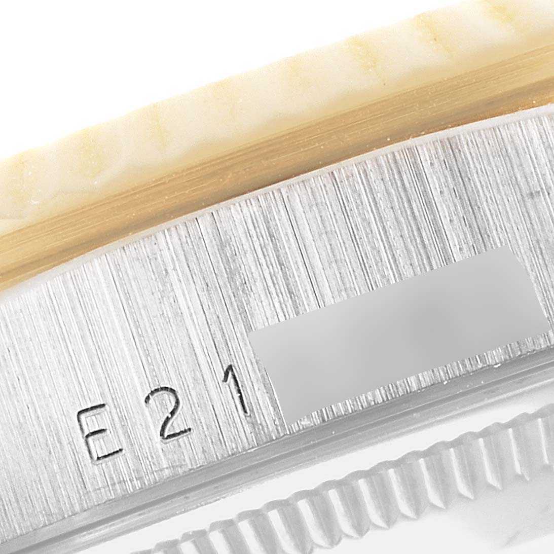 This close-up image shows the side of a Rolex President 18239 Men
s White Gold Brown Dial 18239 Men
s White Gold Brown Dial model watch with engraving and textured details.