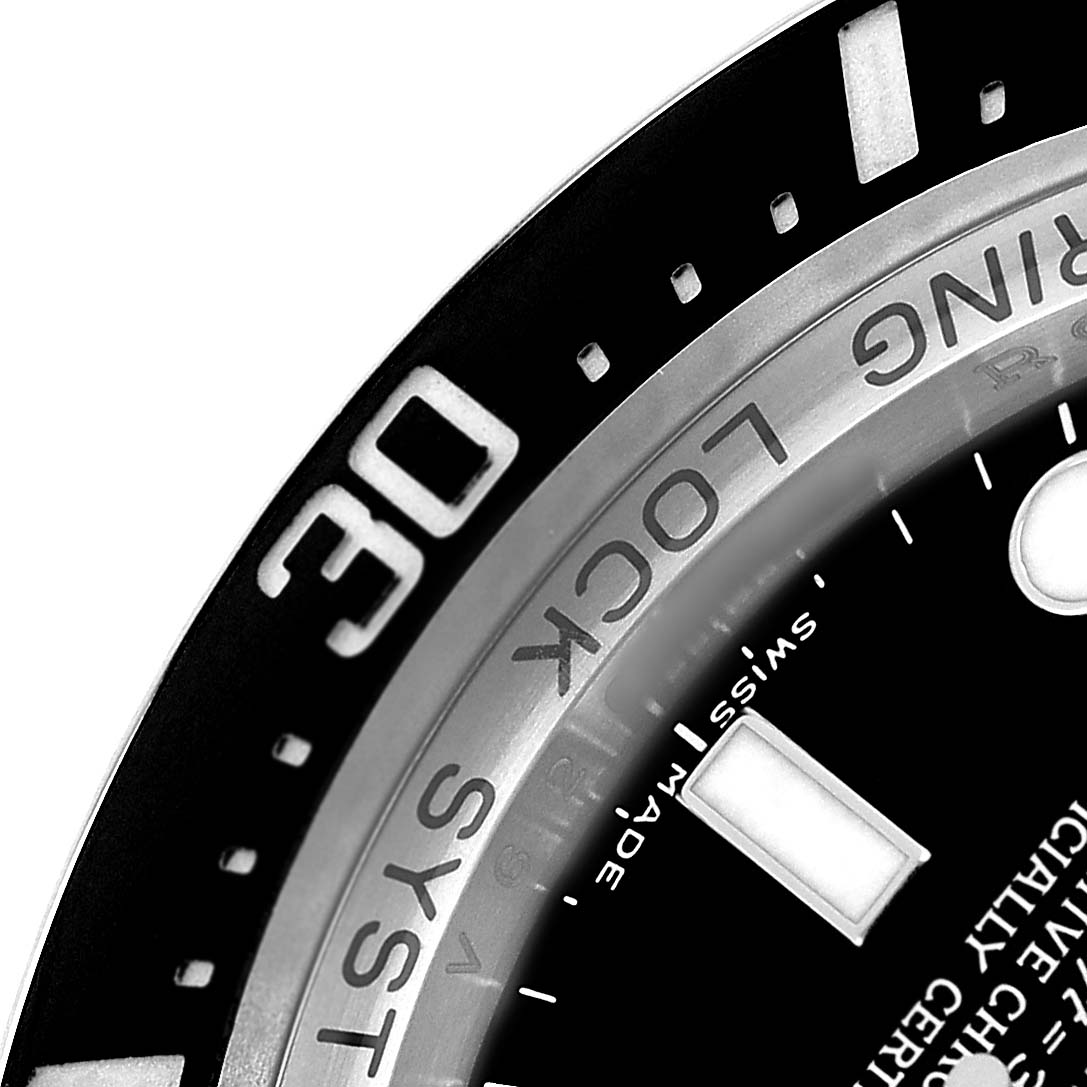 The image shows a close-up of the bezel and part of the dial of the Rolex Sea-Dweller 116660 Men's Stainless Steel Black Dial, highlighting the "Ring Lock System."