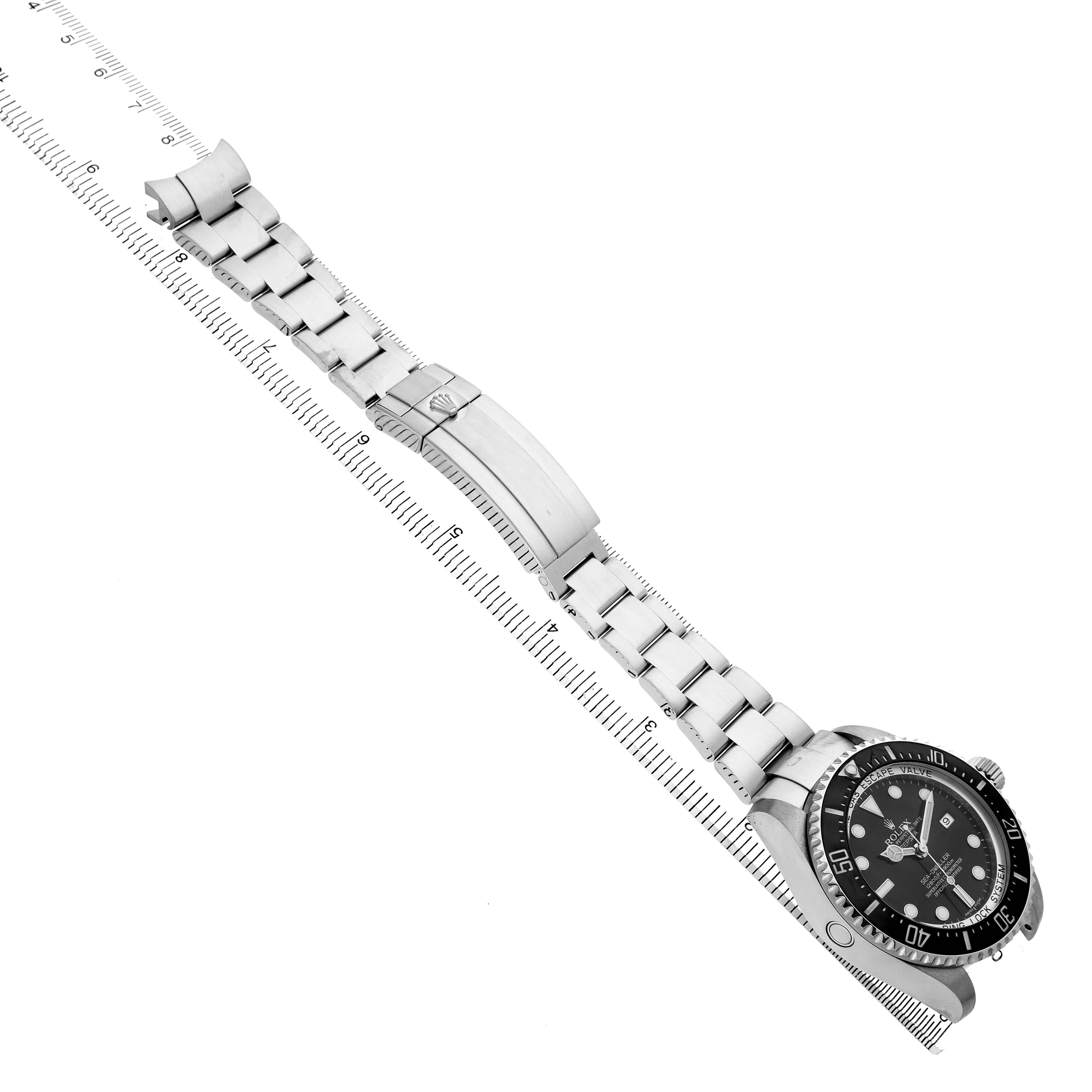 The Rolex Sea-Dweller 116660 Men's Stainless Steel Black Dial is shown at an angle, displaying the bracelet, clasp, and watch face alongside a ruler for scale.