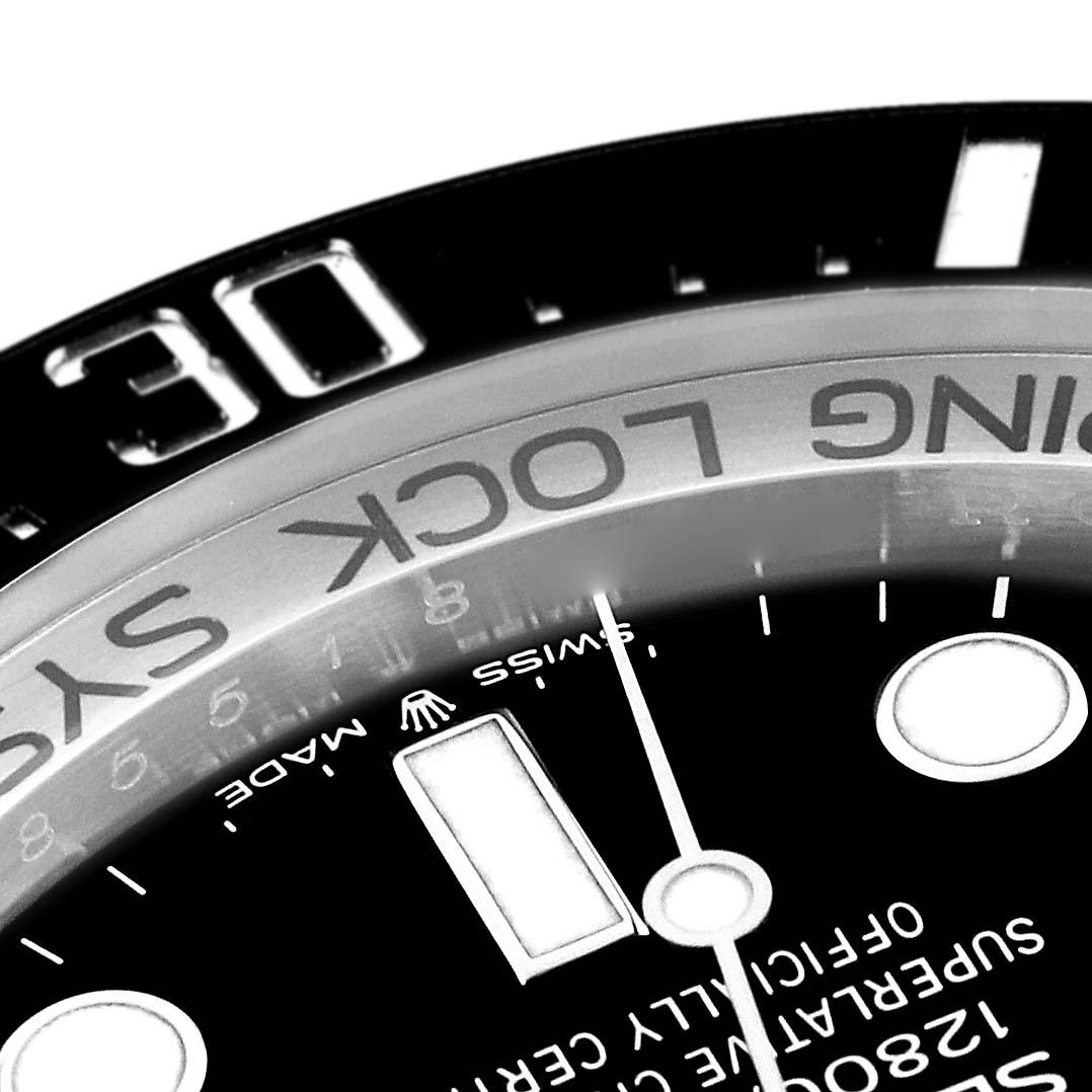 This close-up view of the Rolex Sea-Dweller 136660 Men's Stainless Steel Blue Dial 136660 Men's Stainless Steel Blue Dial watch shows its bezel, part of the dial, and some inscriptions.