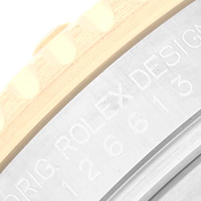 This image shows a close-up of the edge of the bezel and engraved inner ring of a Rolex Submariner 126613 Men's Steel and Gold (two tone) Black Dial 126613 Men's Steel and Gold (two tone) Black Dial.