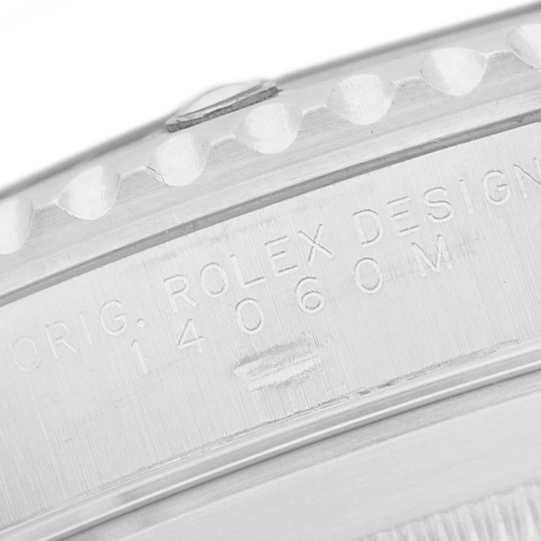 The image shows a close-up of the side engraving on a Rolex Submariner 14060 Men's Stainless Steel Black Dial watch, highlighting the model number and design details.