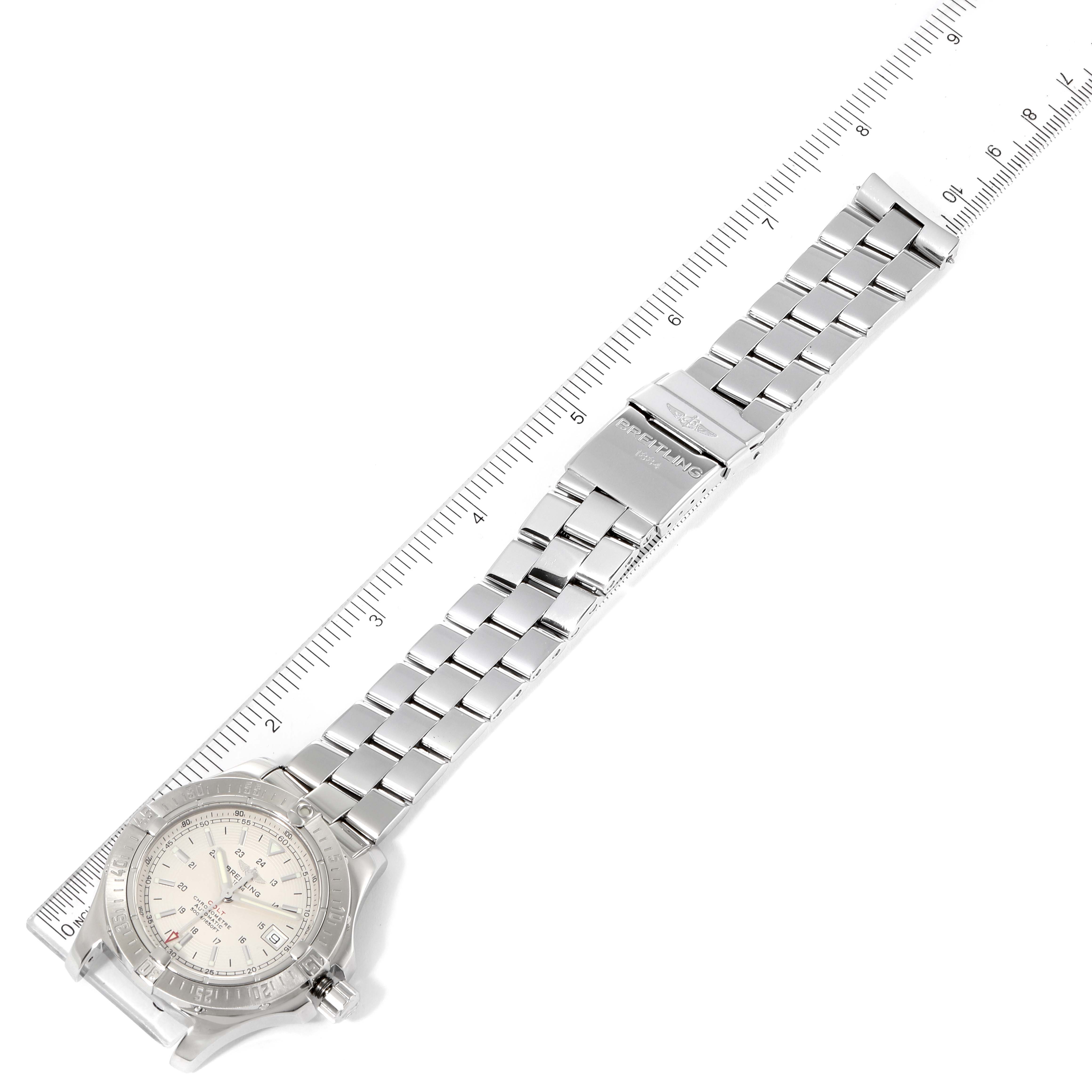 The image shows a top-down view of a Breitling Colt A17380 Men's Stainless Steel Silver Dial A17380 Men's Stainless Steel Silver Dial watch, including its face, bezel, and metal bracelet with a clasp near a ruler.